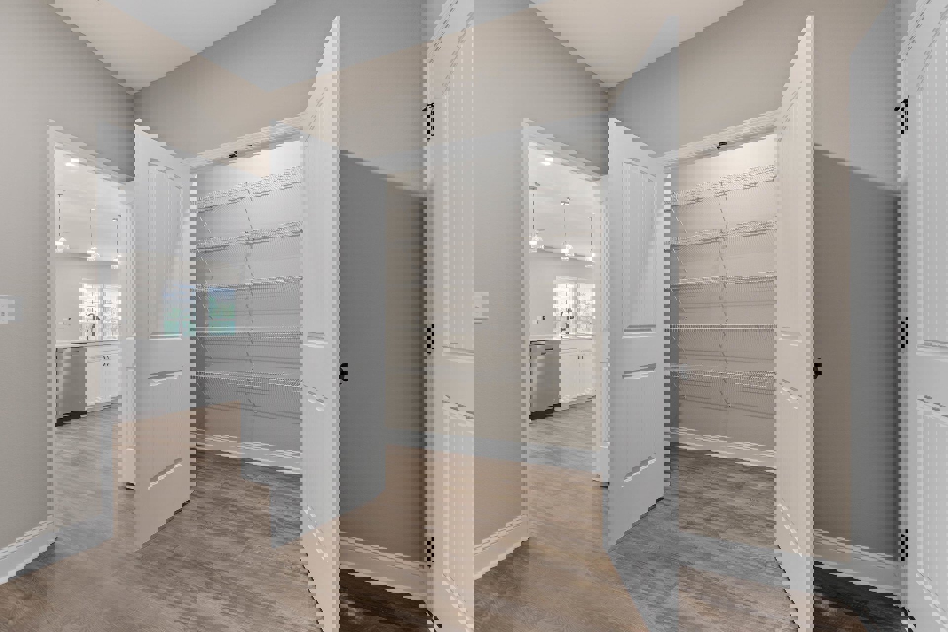 White paneled door with black hinges opens into a room featuring built-in white shelves, light wood flooring, and white cabinetry.