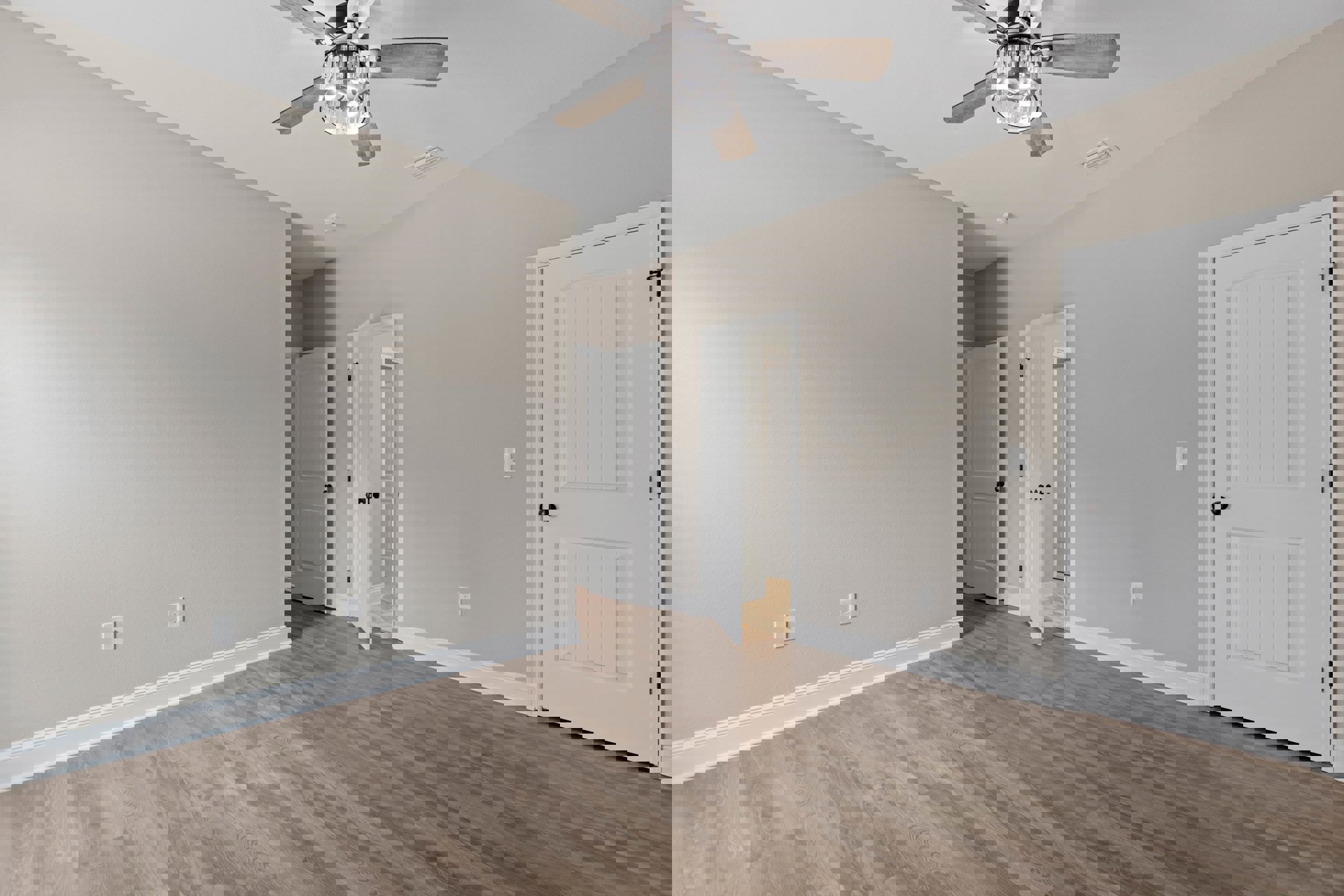 Wood floor room with white doors featuring black knobs, ceiling fan with crystal chandelier, plaster walls, and laminate flooring