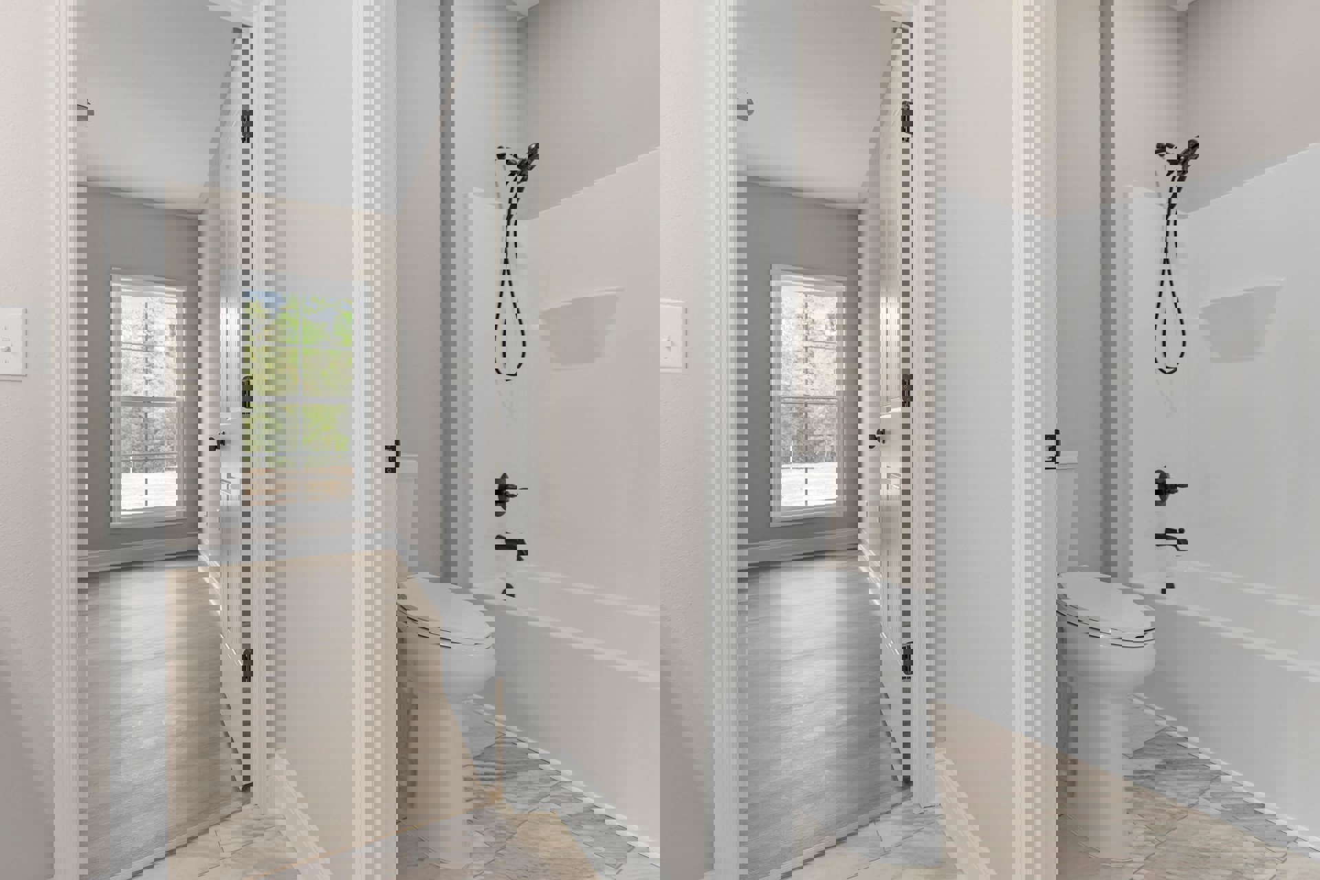 White bathtub and toilet on wood flooring, window with trees outside, light-colored tile walls, simple modern fixtures