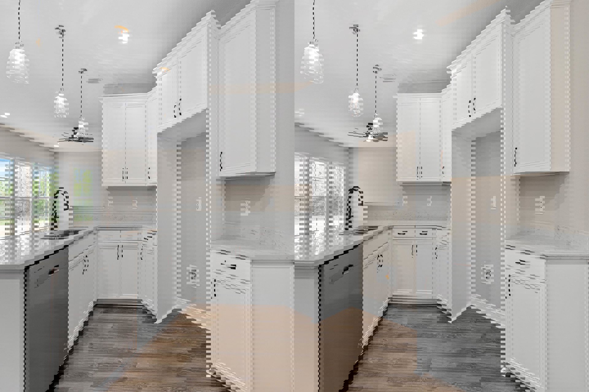 White kitchen cabinets with brushed metal handles, wood plank flooring, stainless steel sink and faucet, clear glass pendant light fixture, stone countertop, and built-in