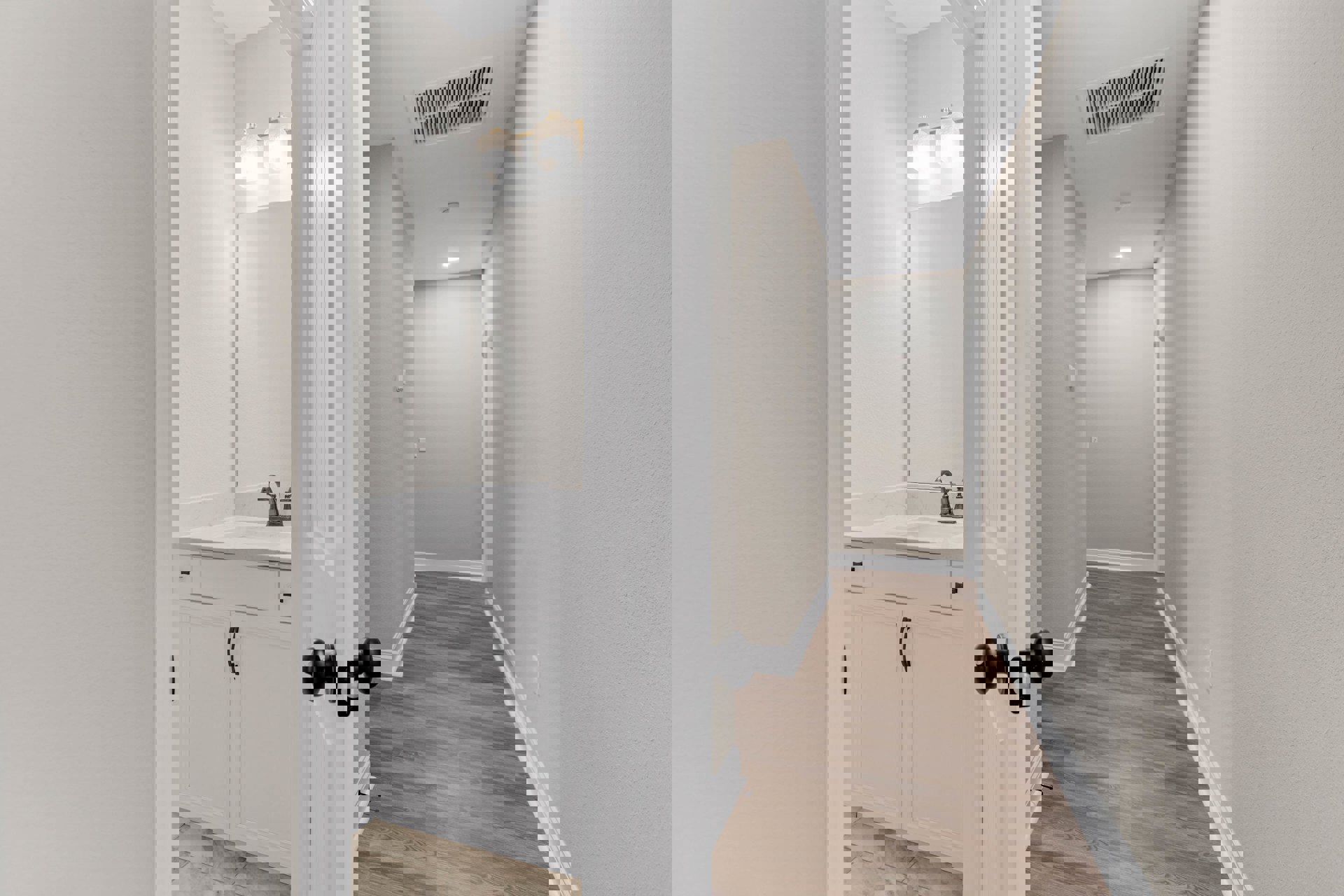 Hallway with white paneled door, wood plank flooring, white baseboards, ceiling vent, and recessed light fixture; bathroom visible with matching wood floor and white door