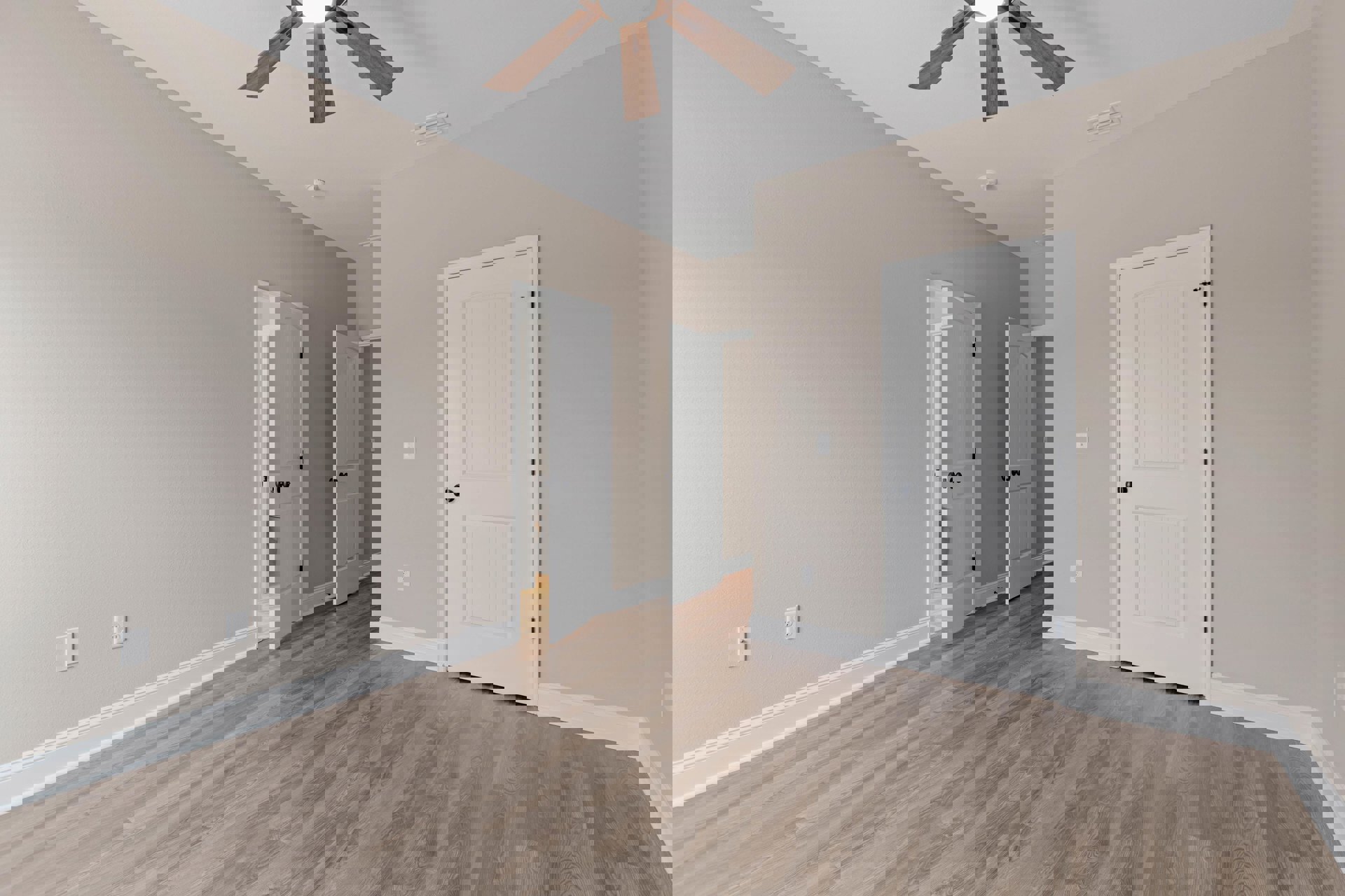 Room with wood laminate flooring, white paneled doors featuring black knobs, neutral walls, and a ceiling fan with integrated light fixture