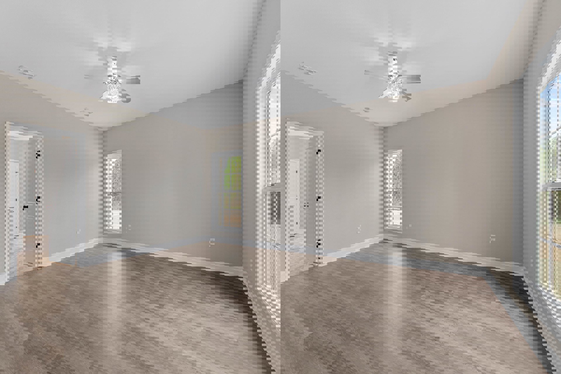 Hardwood floor room with white walls, large window overlooking outdoors, ceiling fan featuring crystal light fixture, decorative molding along ceiling edges