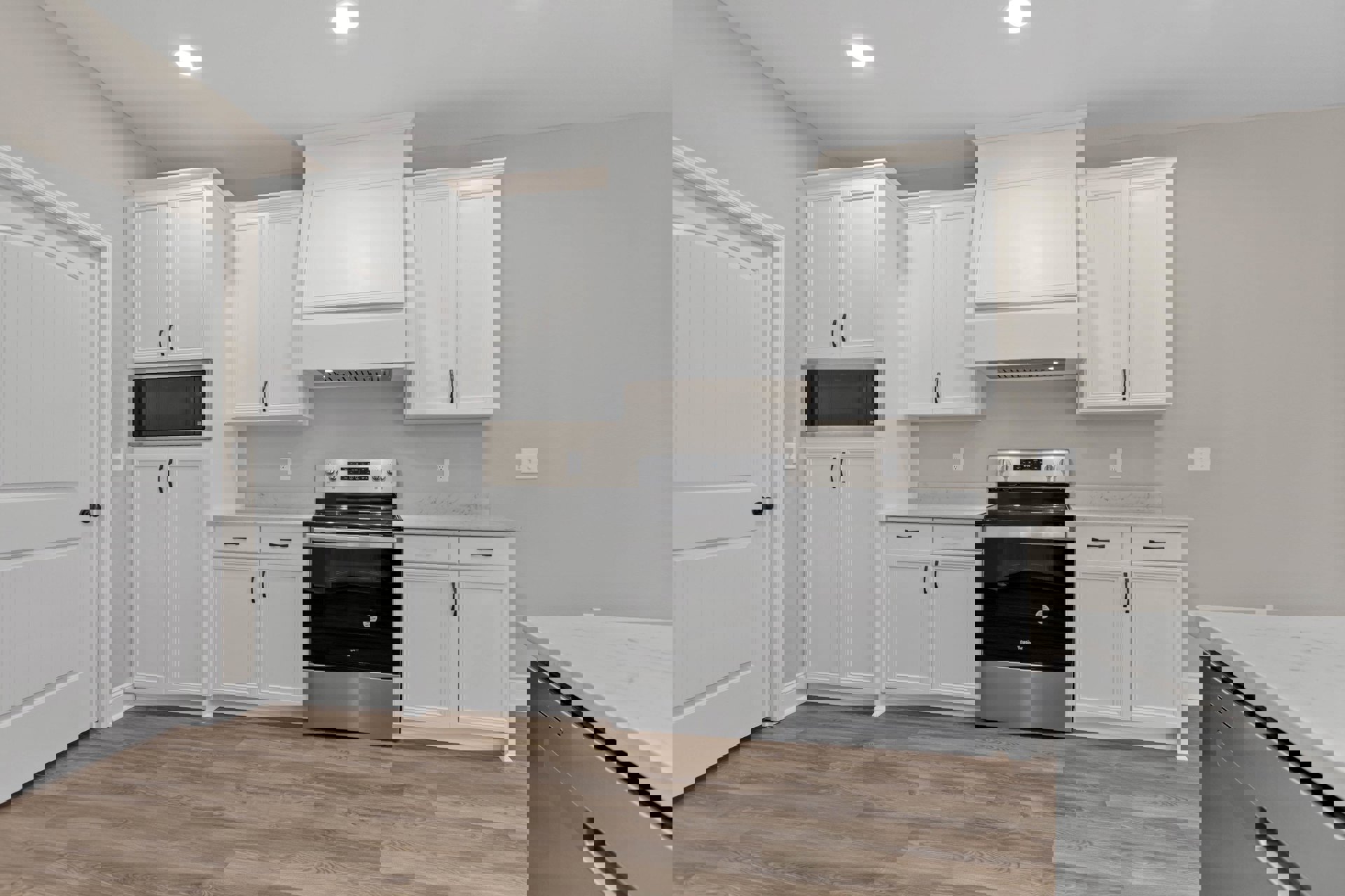 White kitchen cabinets with silver handles, black and silver stove, white-framed microwave, wood flooring, and a white door with black knob.