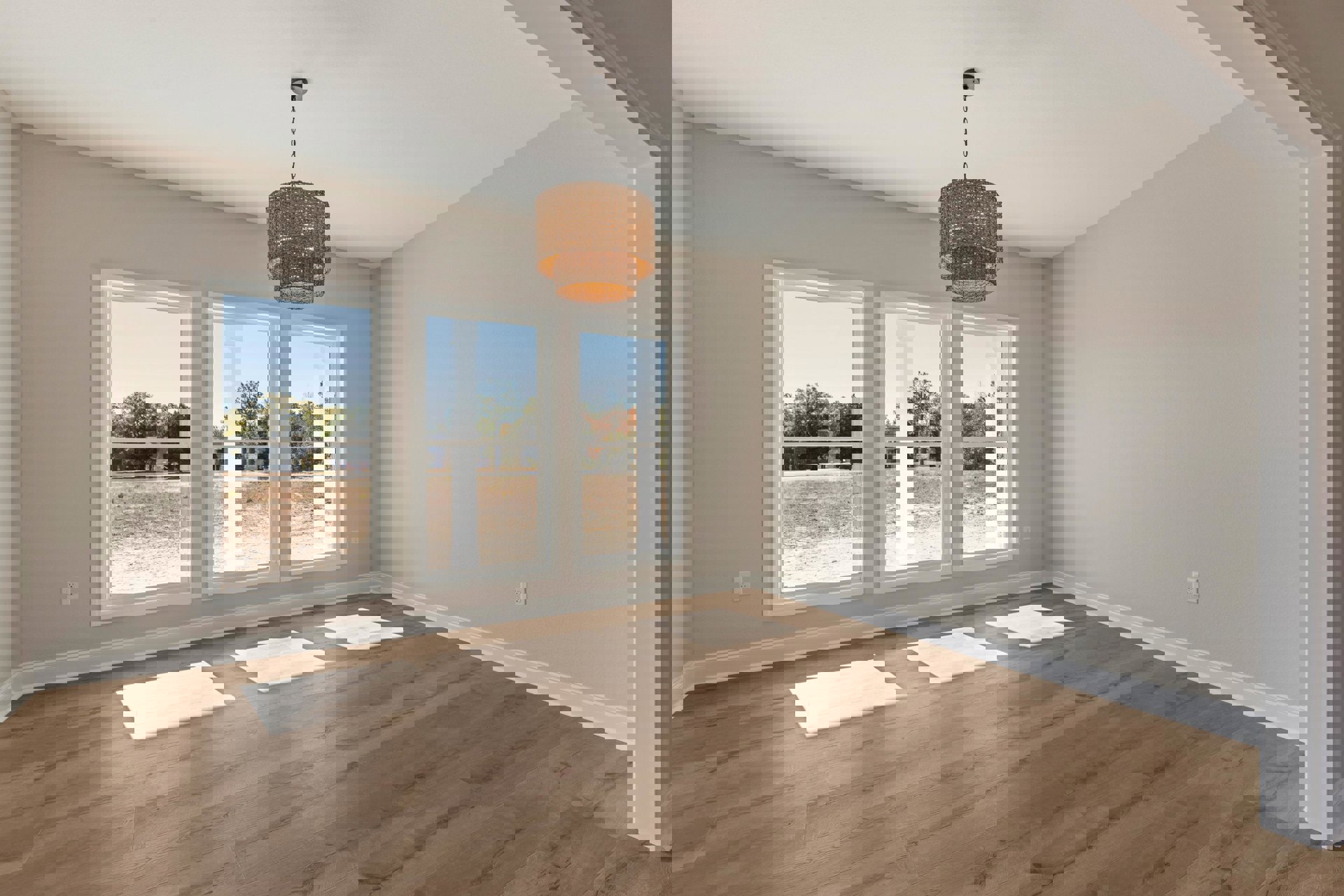 Open-concept room featuring a woven shade chandelier, large windows, wooden flooring with white square tiles, and a white table casting a shadow.