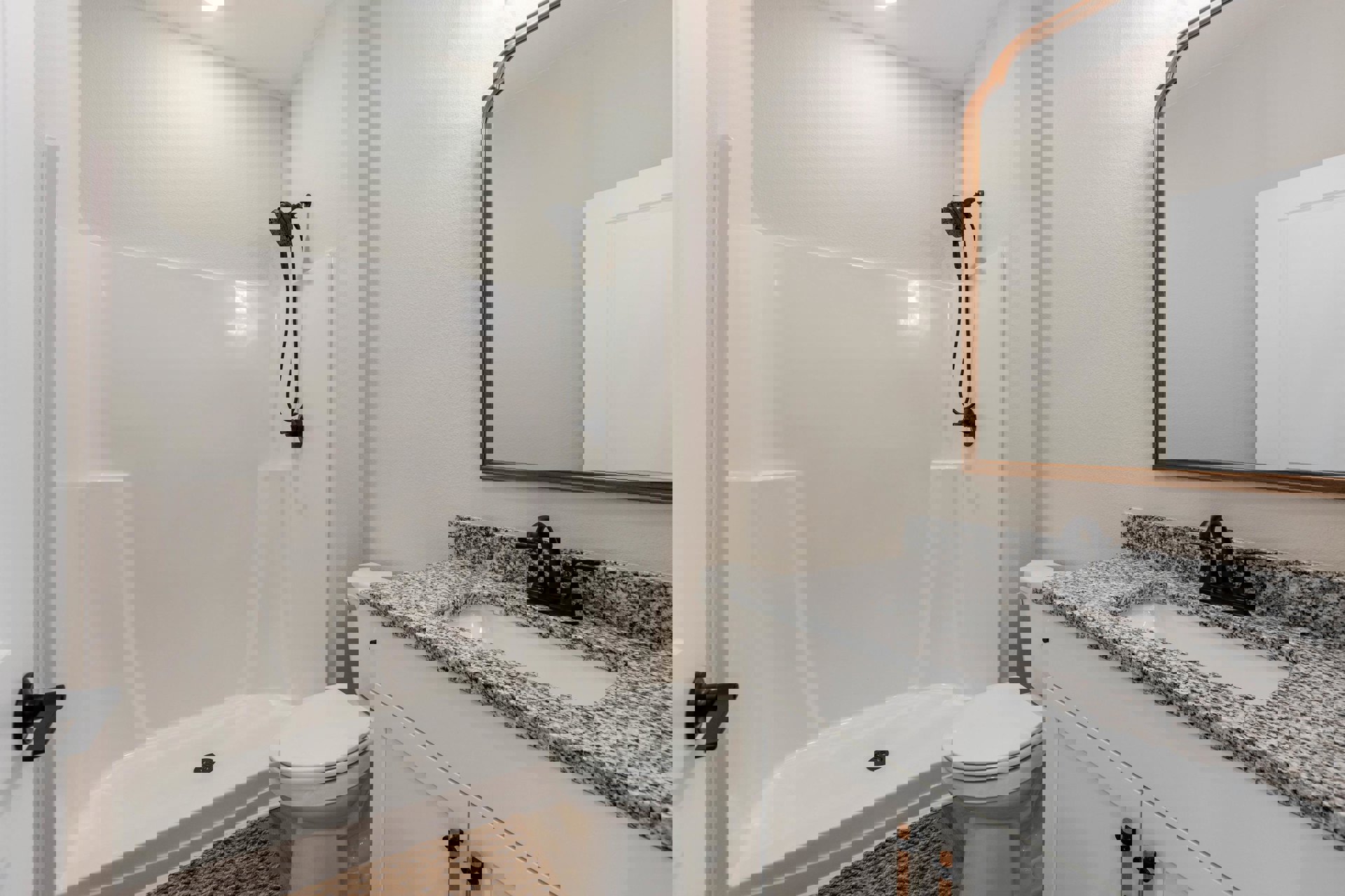 Bathroom with white tile floor, white bathtub featuring a black hose, white toilet, sink with cabinet, gold-framed mirror, and close-up of white door.