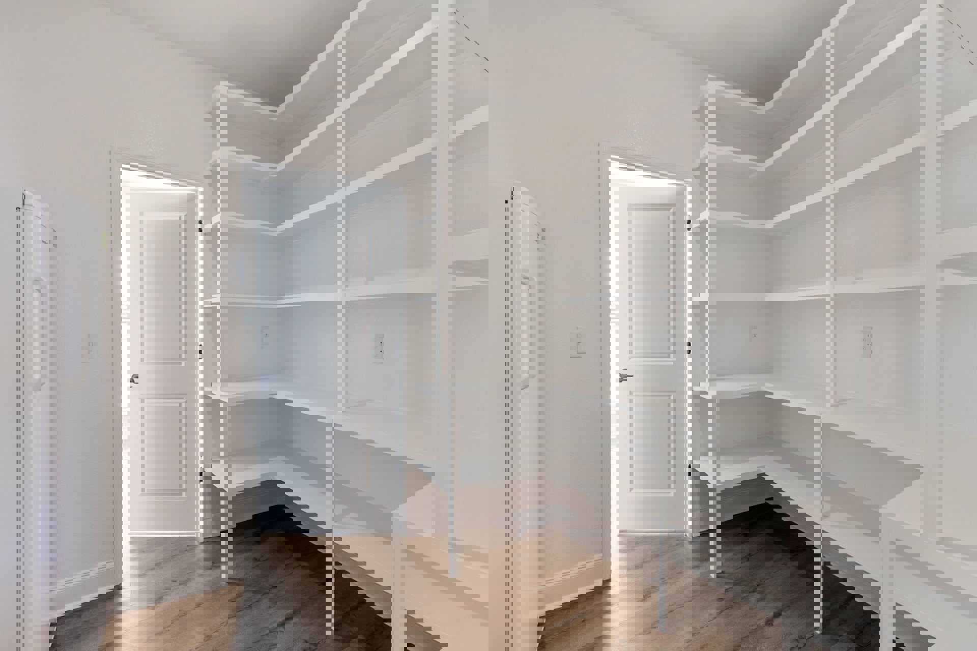 Built-in white shelving unit beside a white paneled door with silver handle, light-colored flooring, white walls, and minimalist cabinetry