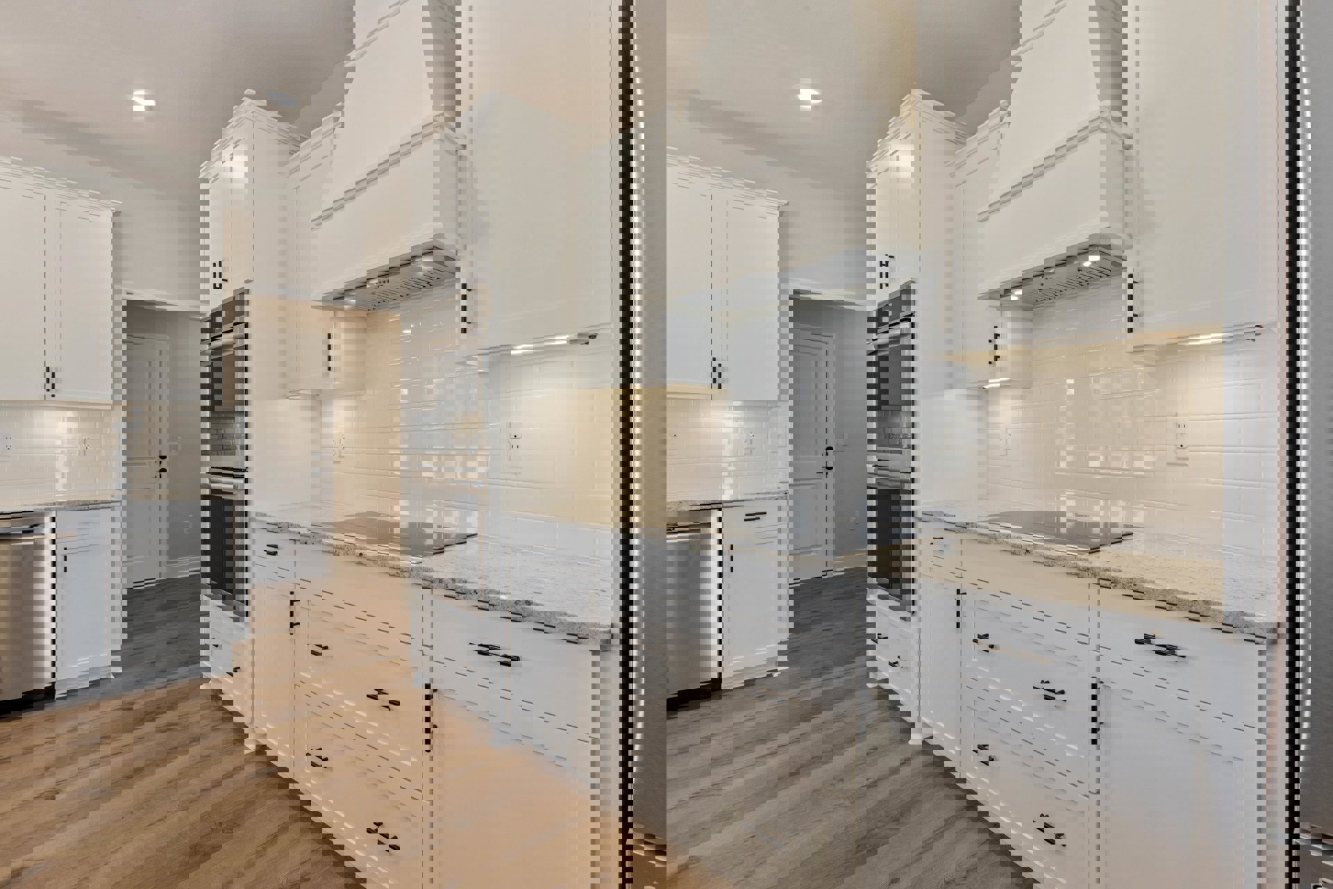 Kitchen with white shaker cabinets, white tile flooring, stainless steel microwave, silver countertop, white doors with contrasting brown and black handles, and black cabinet