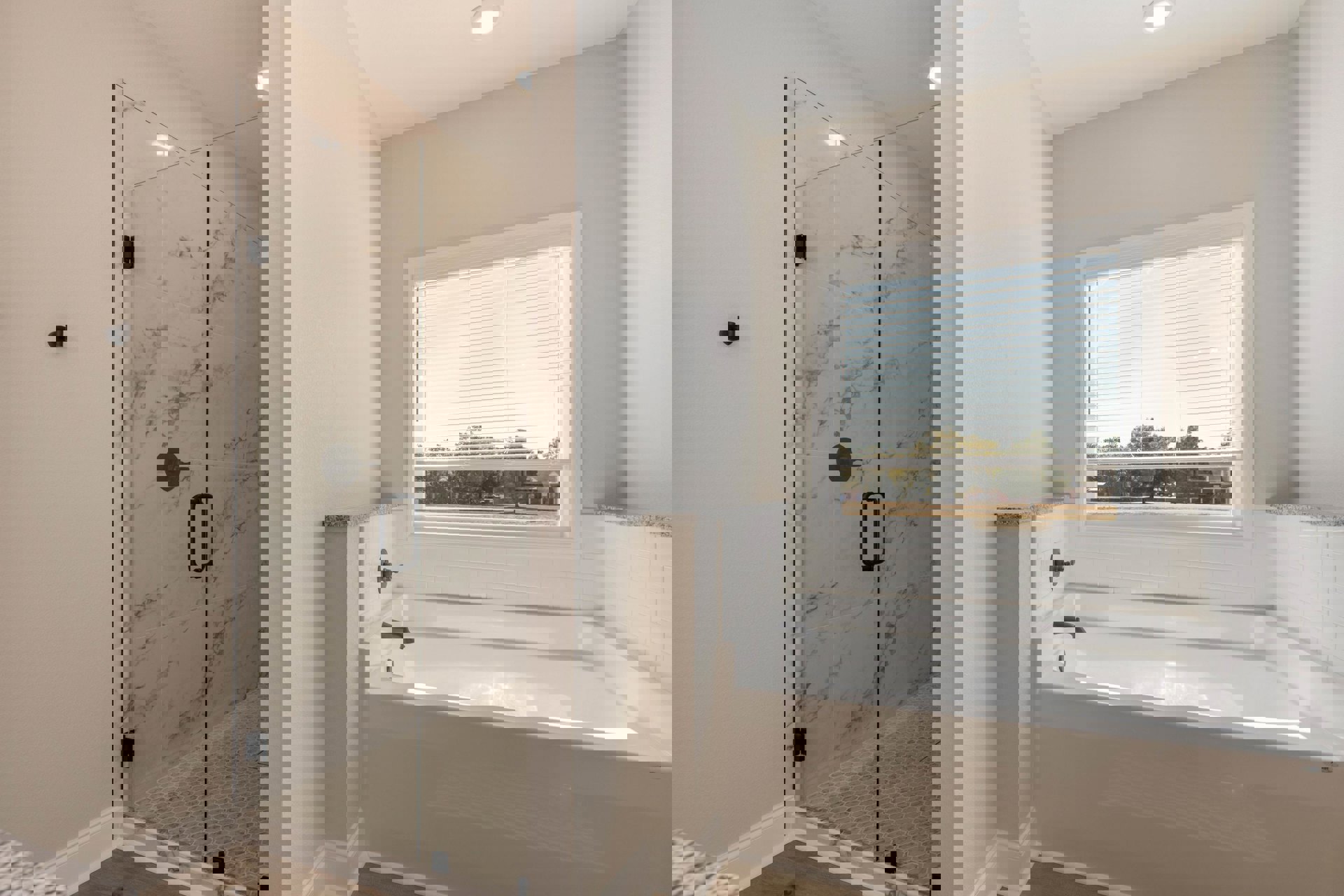 White bathtub with chrome faucet beside glass-enclosed shower, tile walls, window with white blinds, black metal towel bar.
