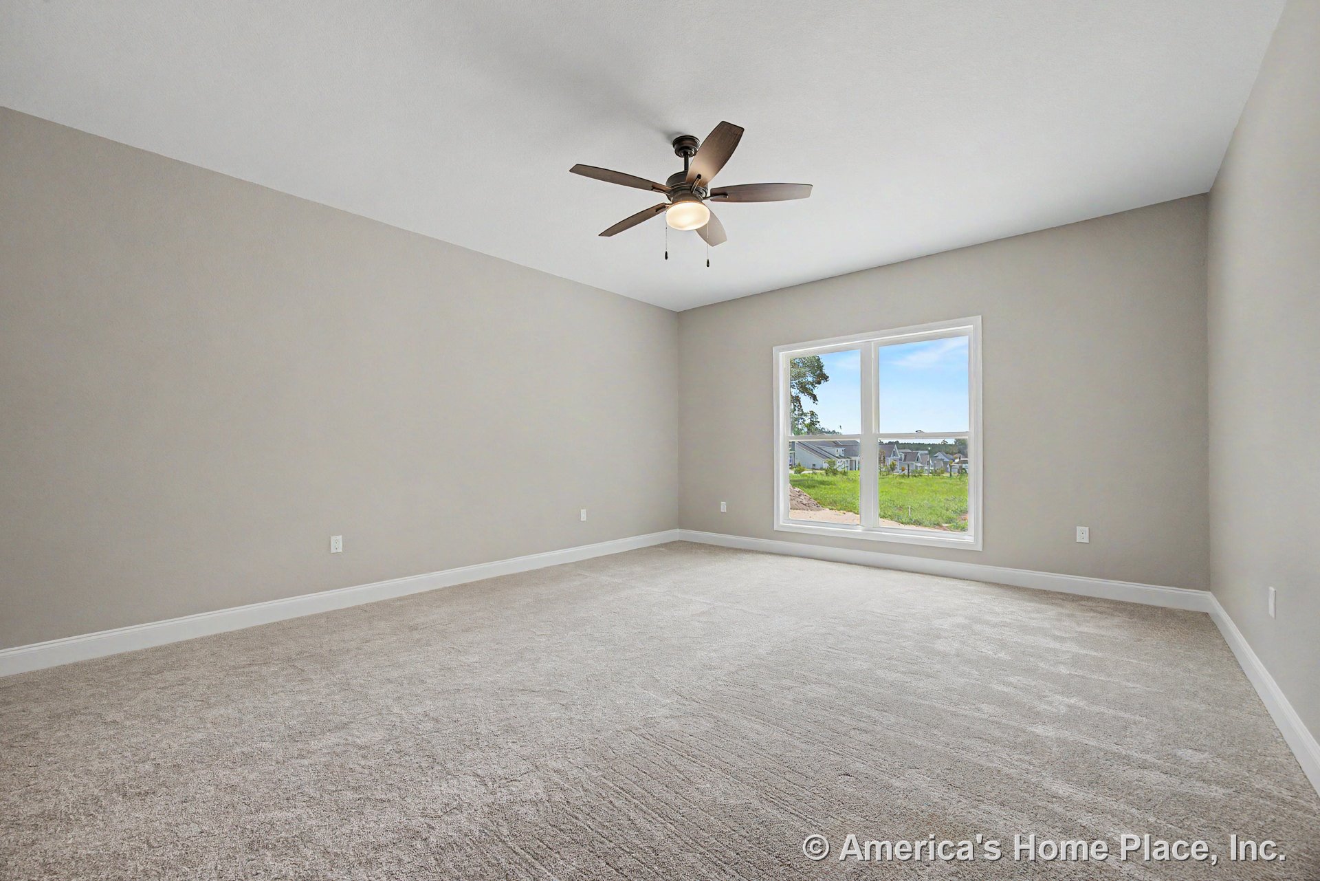 Ceiling fan with built-in light fixture, large double window allowing natural light, carpeted floor, neutral painted walls, white baseboard trim, spacious modern bedroom layout.