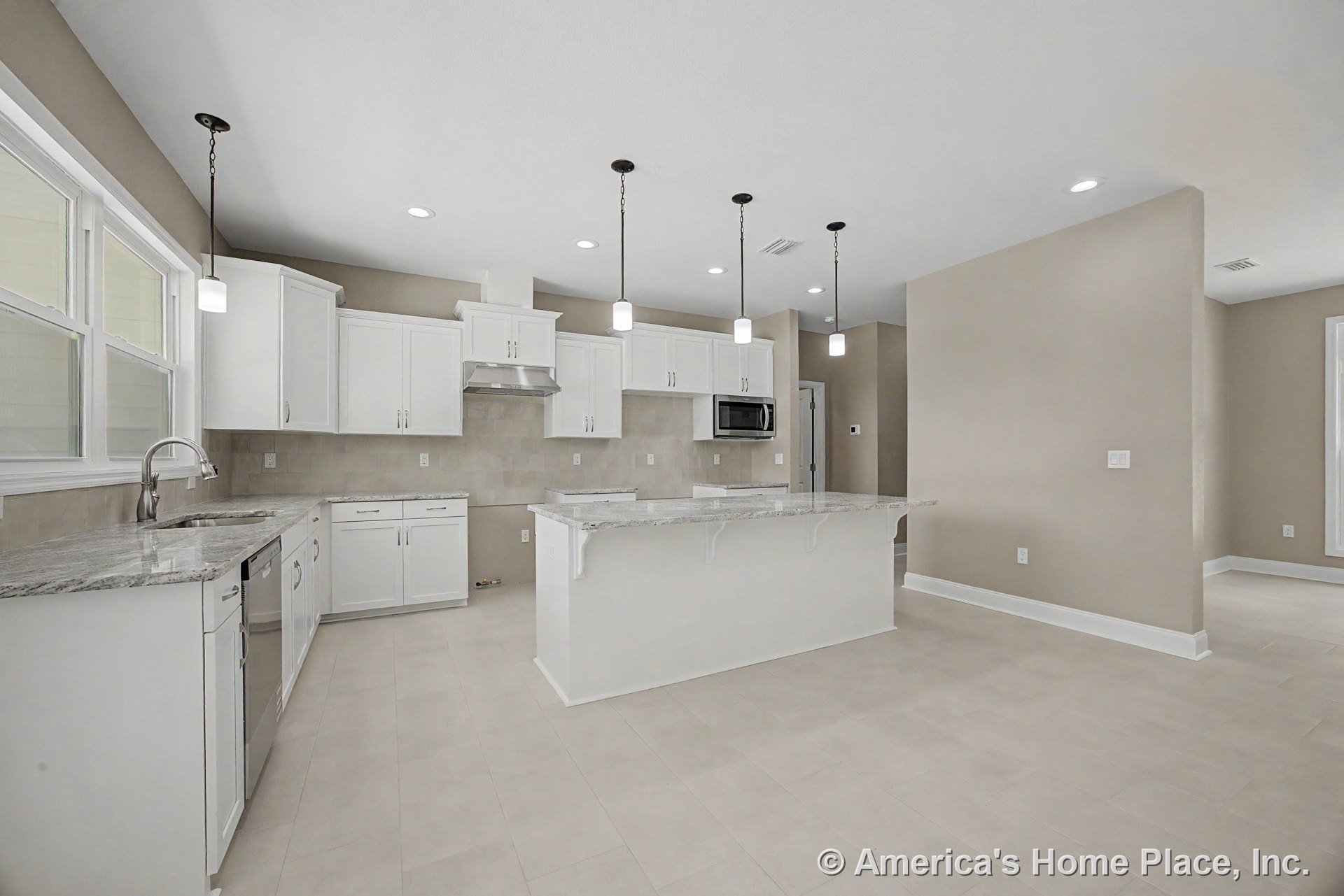 White shaker cabinets with granite countertops, tile backsplash, stainless steel appliances, and pendant lights above a large central kitchen island; tile flooring and recessed