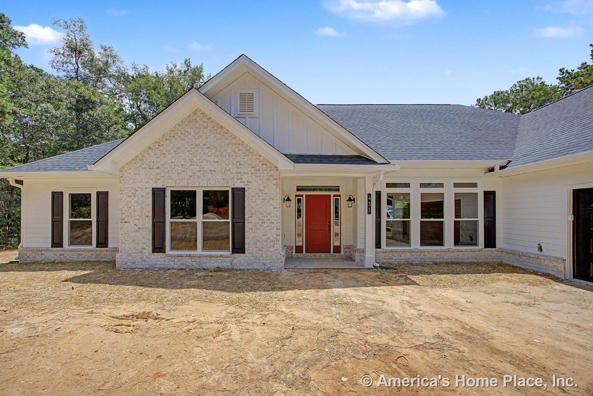 Light brick exterior with board and batten siding, covered entry porch, red front door, black window shutters, and multiple large windows.