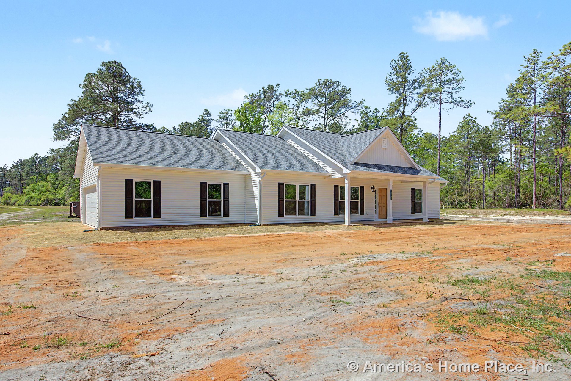 White horizontal siding with black window shutters, covered front porch supported by columns, gable roof with asphalt shingles, multiple large windows, wood front door, and crisp