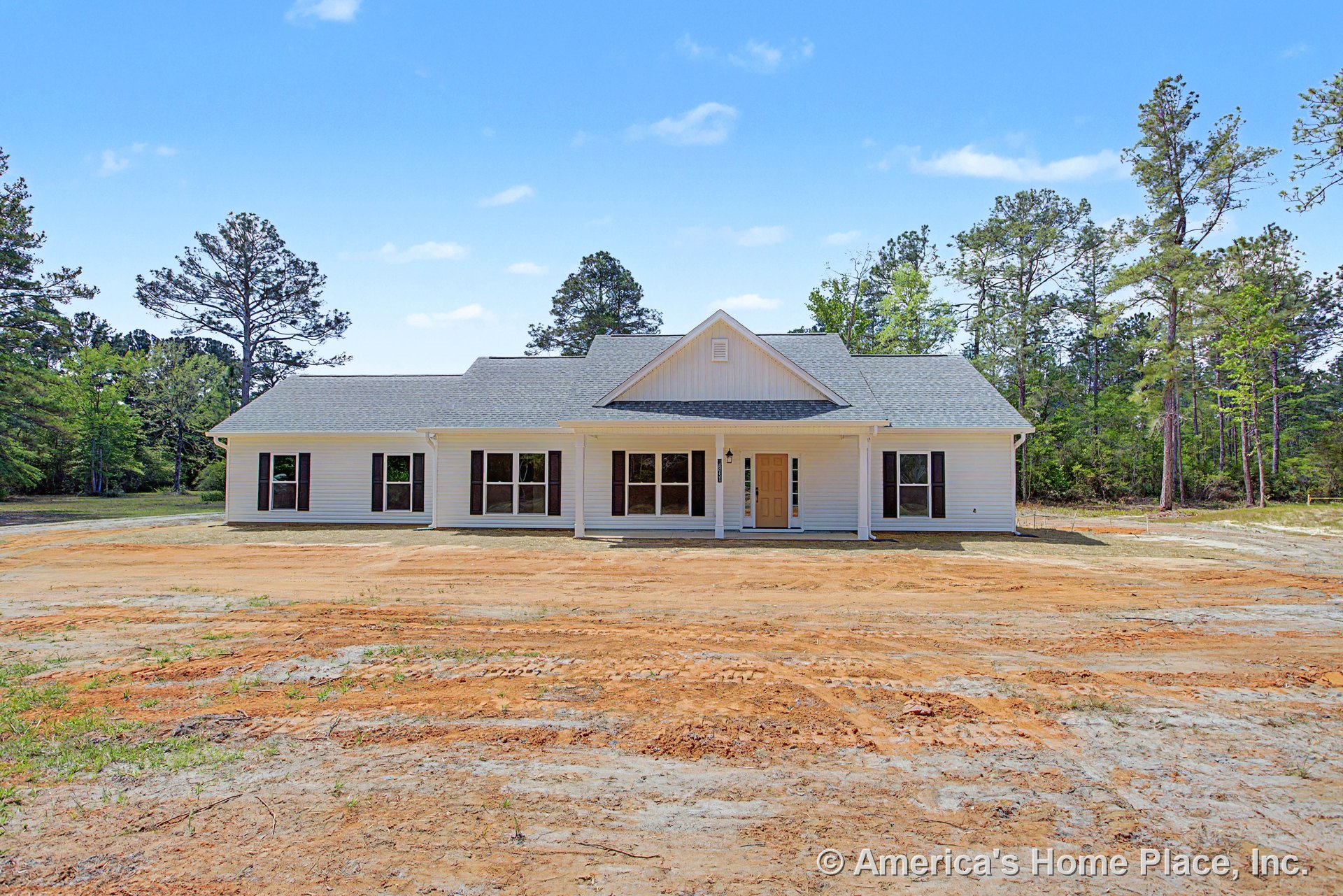 Covered front porch with white columns, white exterior siding, gabled roof, multiple large windows with dark shutters, central front door, and decorative trim on a single-story