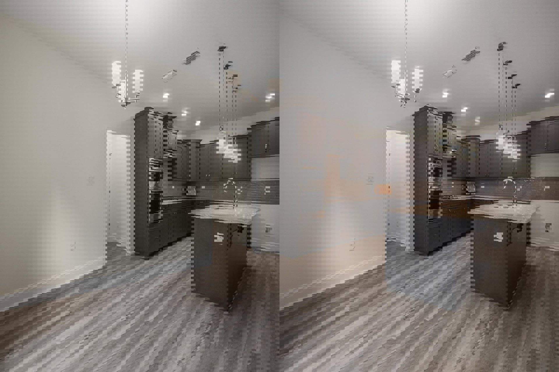 Kitchen with light wood flooring, white cabinetry, stainless steel oven, central island featuring a built-in sink and chrome faucet, pendant light with white shade above island