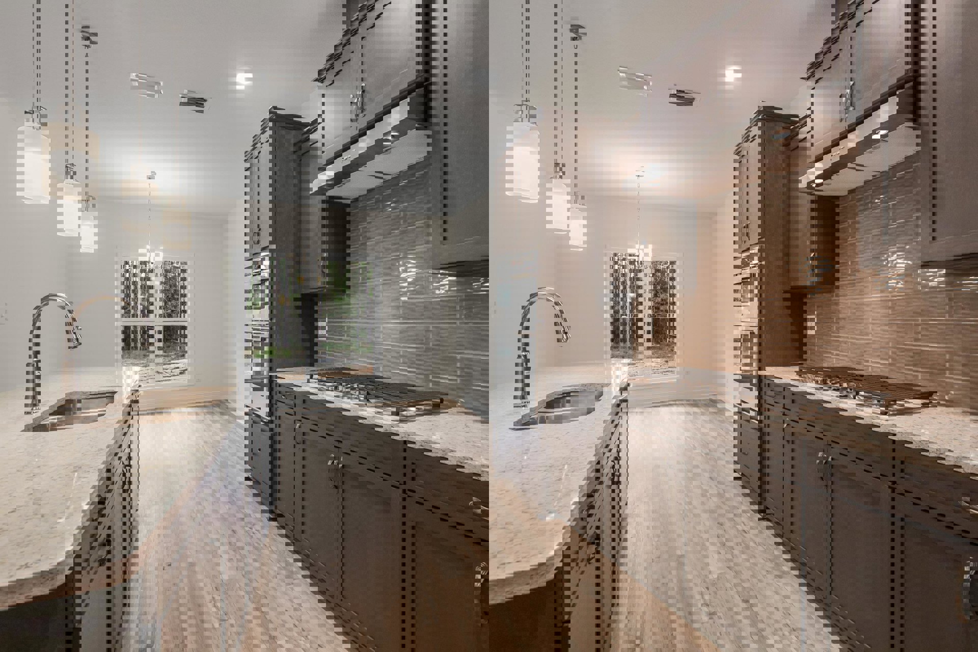 Dark wood cabinets and matching wood floor in a kitchen, stainless steel faucet at the sink, stone countertop, ceiling light fixture, window with trees visible outside