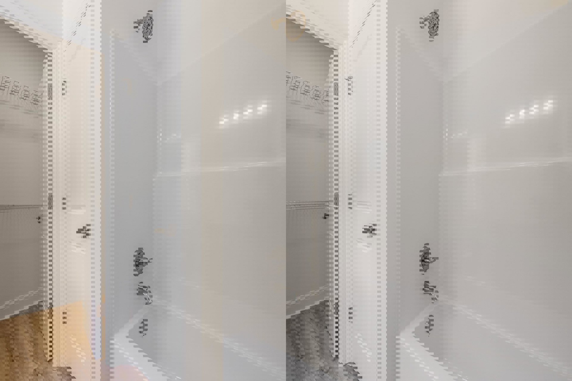 Freestanding white bathtub with chrome faucet and round shower head, surrounded by light tile walls and plaster finishes