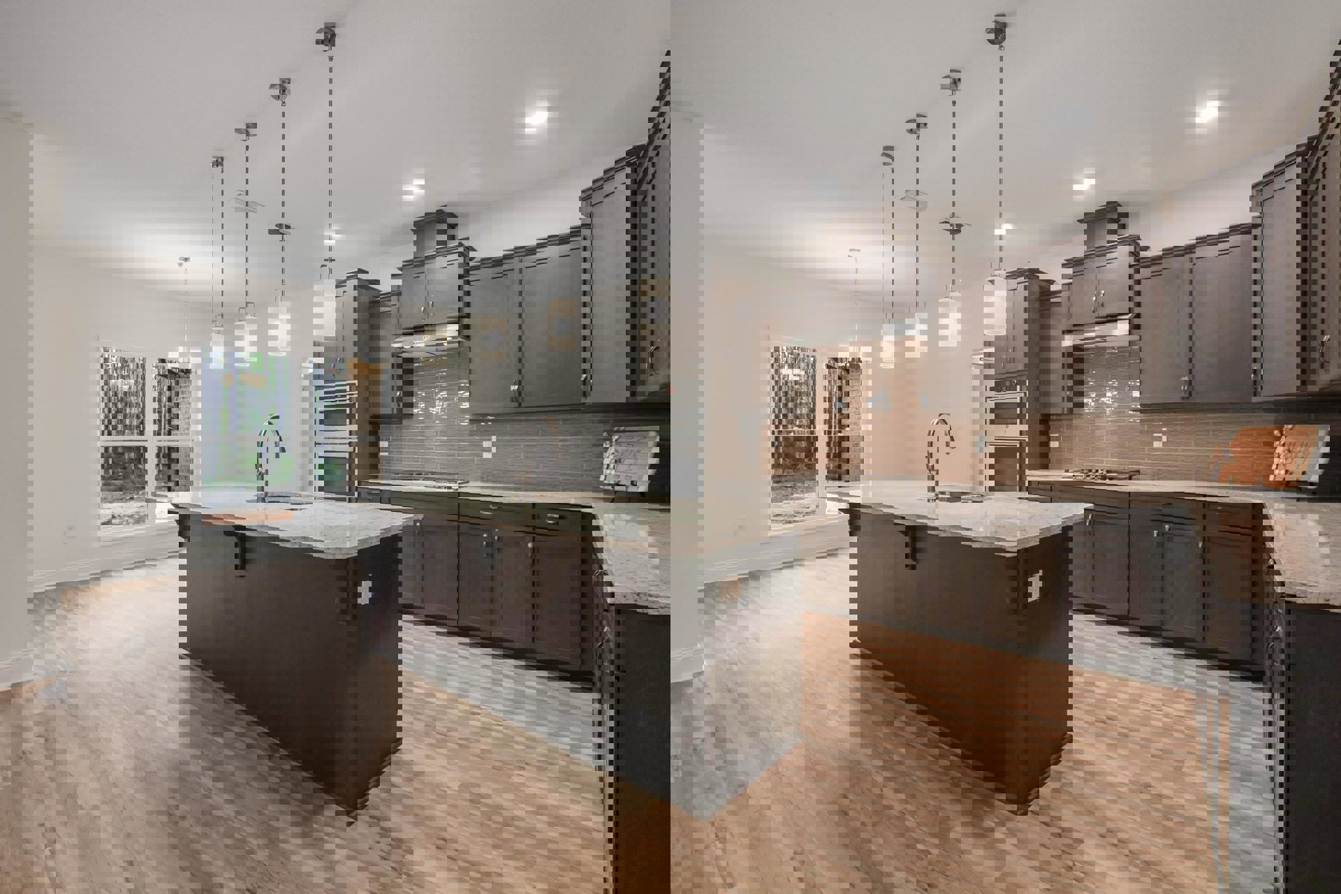 Kitchen with wood flooring, central island featuring a built-in sink, white cabinetry, stainless steel microwave, and stone countertops