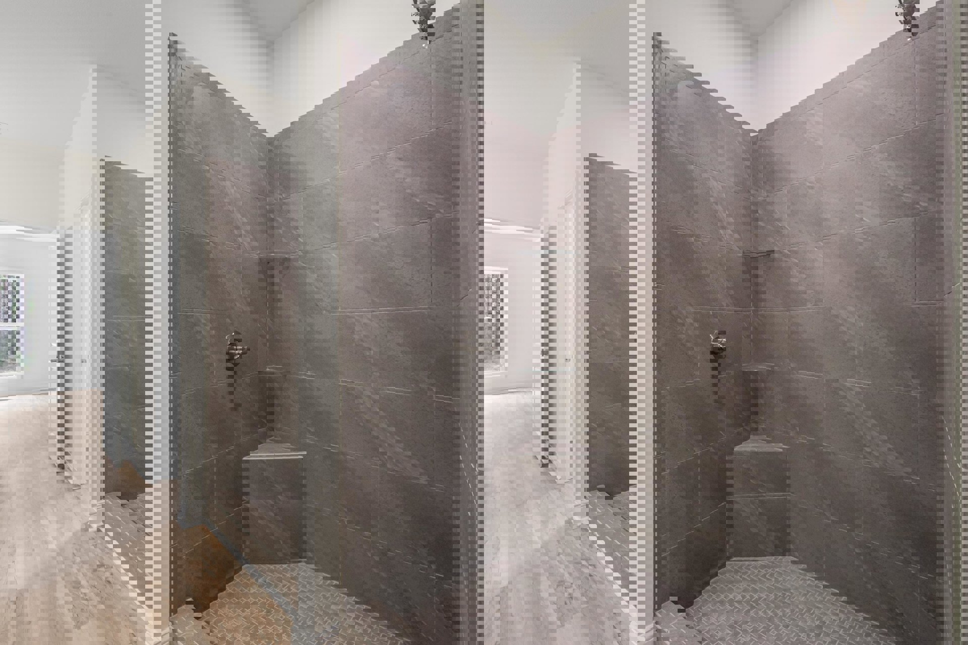 Shower with glass shelf, tile floor, white plaster walls, window with white frame, chrome shower head, marble finishes, close-up of door handle