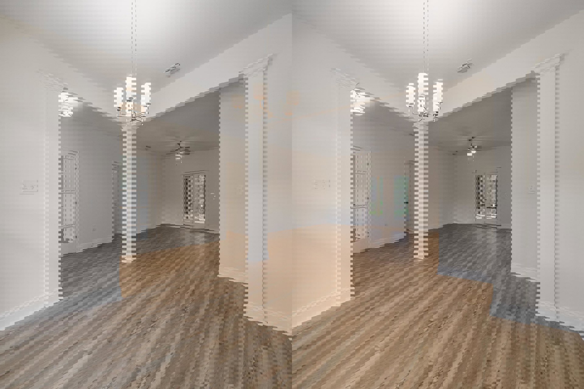 Spacious room featuring wood flooring, ceiling fan, double glass doors, white plaster walls, and modern lamp fixture