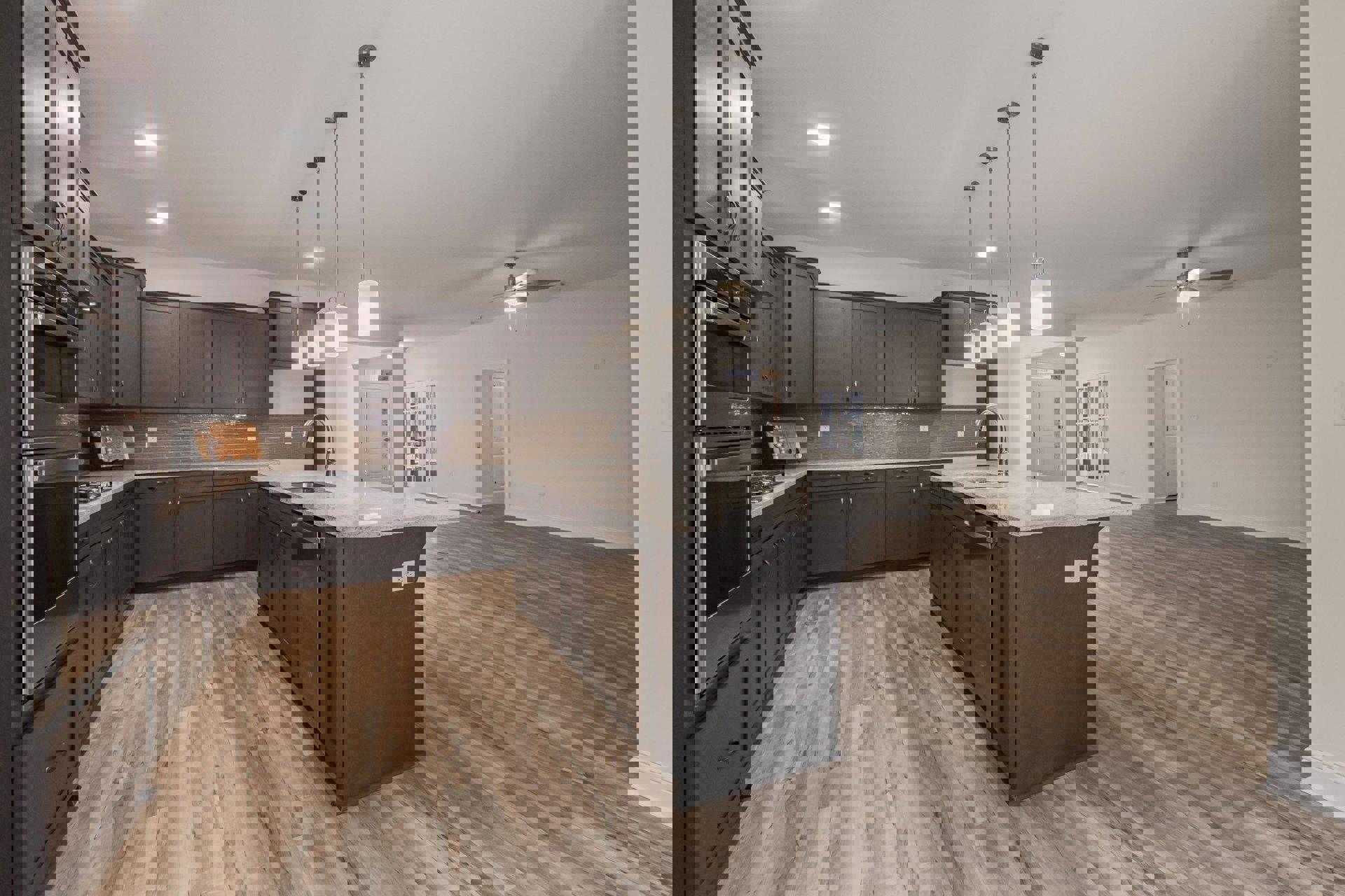 Spacious kitchen featuring a large central island with built-in sink and stainless steel faucet, wood flooring, white cabinetry, overhead light fixture, stainless steel microwave