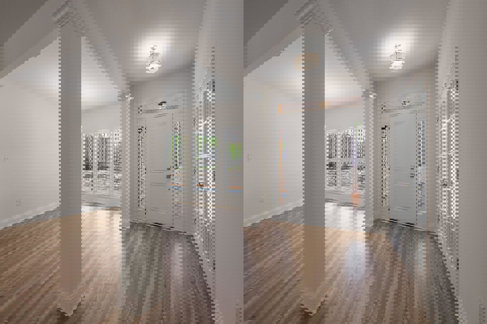 White walls and ceiling, wood plank flooring, white door with silver handle, window in the corner, white column, modern light fixture with white shade.