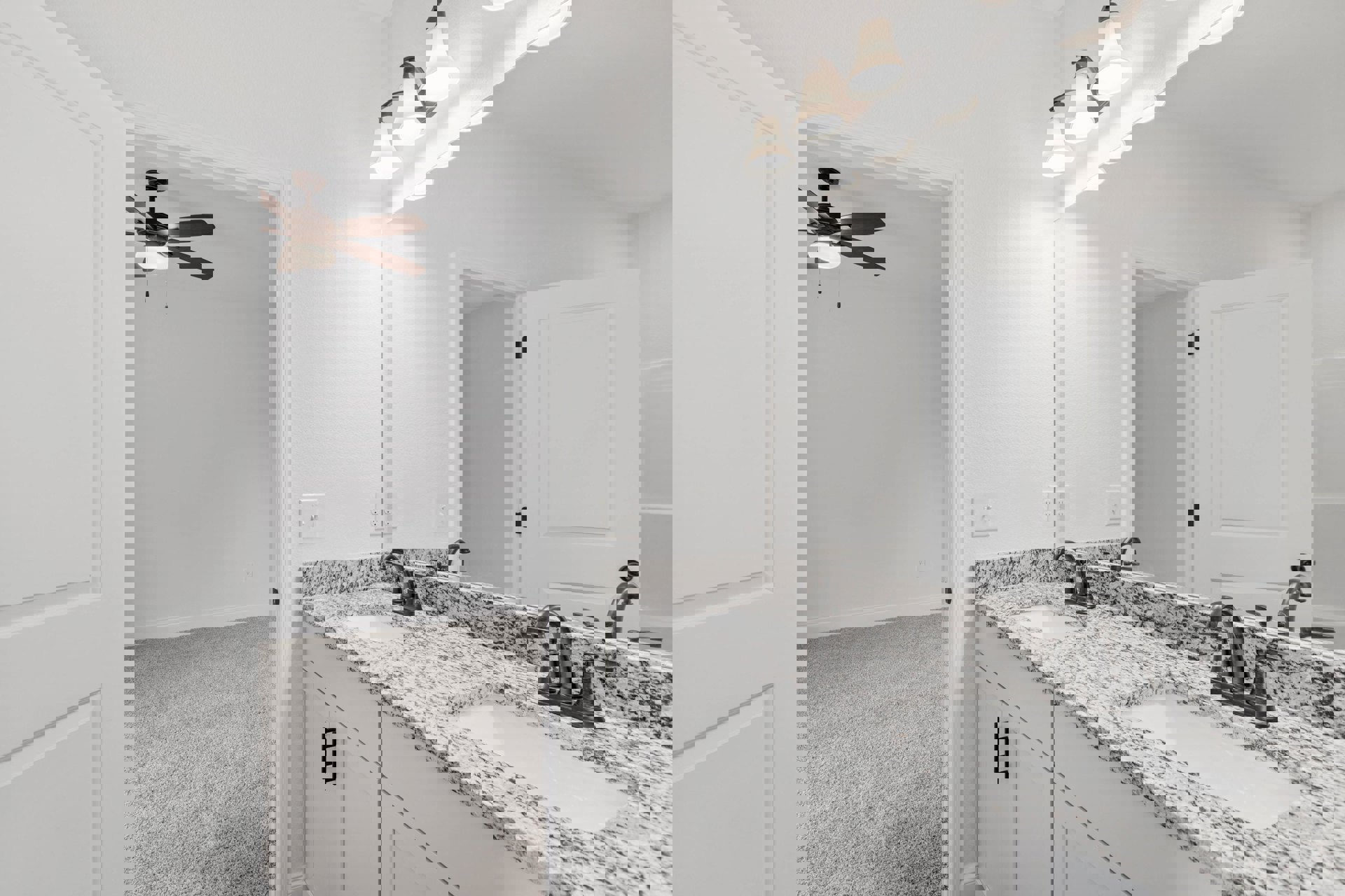 Bathroom with marble countertop, undermount sink, chrome faucet, ceiling fan with light, white door and frame, tile flooring, light switch on wall, partial view of adjacent