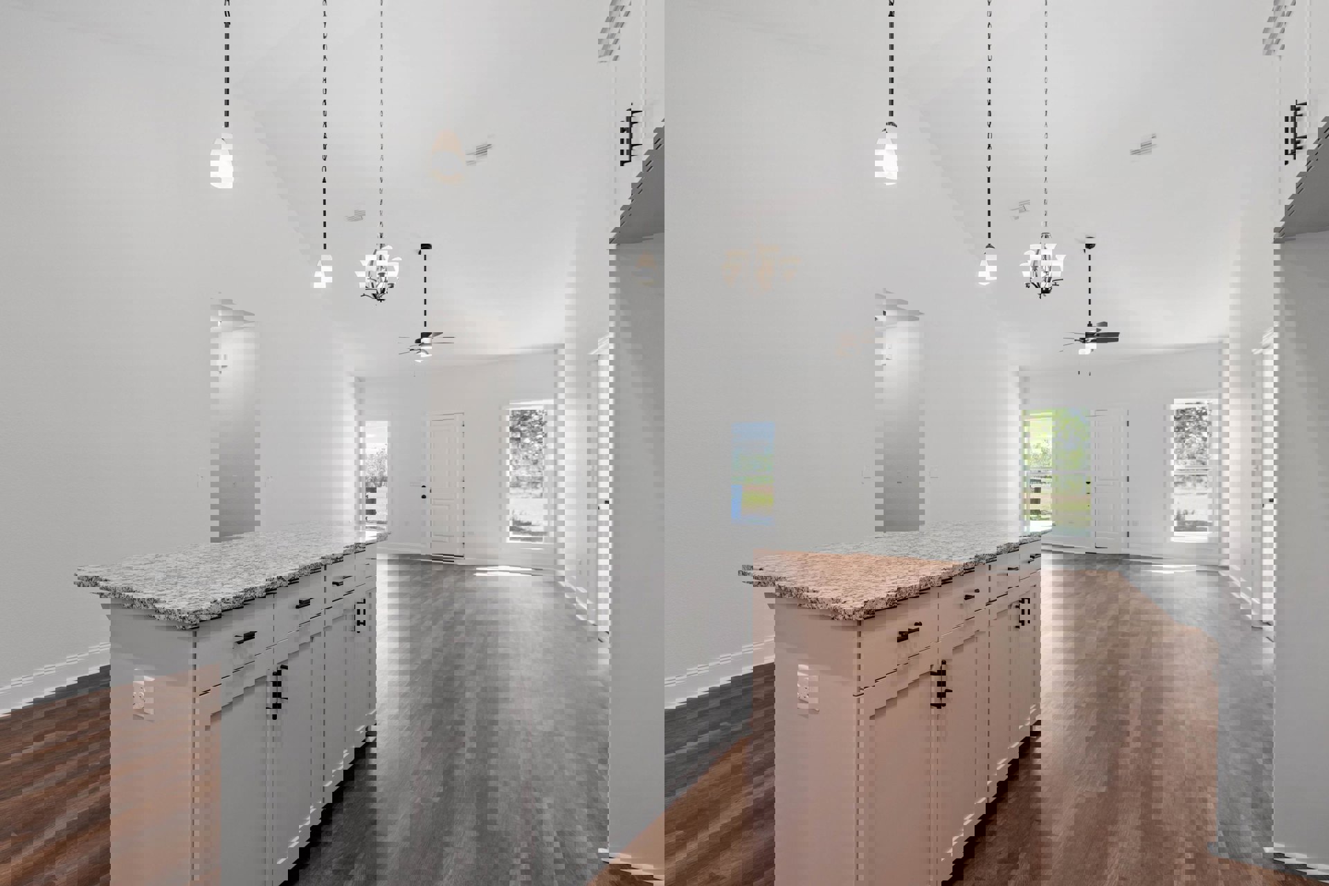 Marble kitchen countertop with white cabinetry and black handles, hardwood flooring, wall-mounted light fixture, window overlooking grassy field, white door with black knobs