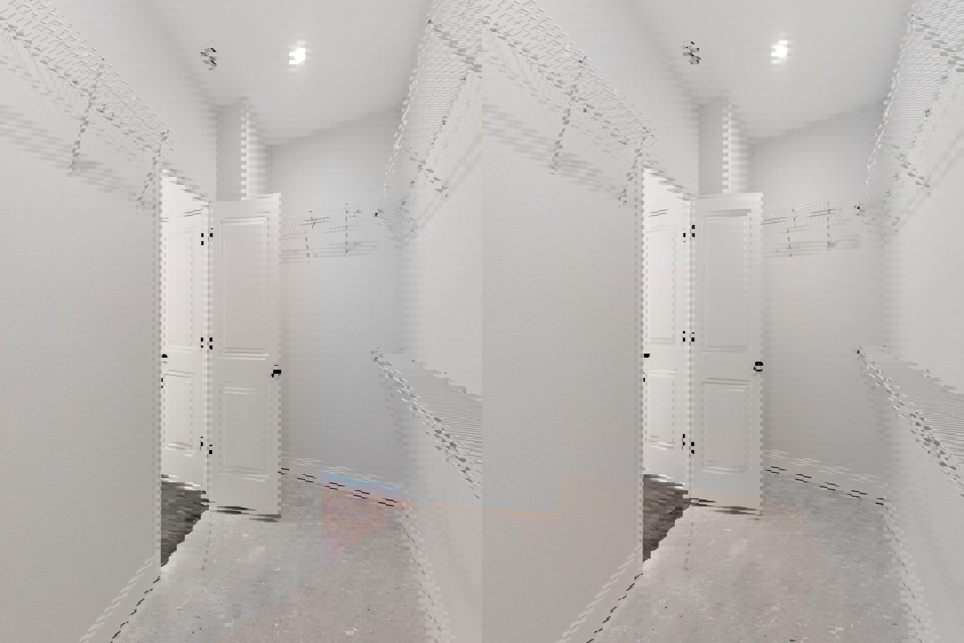 White-walled room with multiple white doors featuring black knobs, concrete floor, ceiling vent, and visible hole in wall near door.