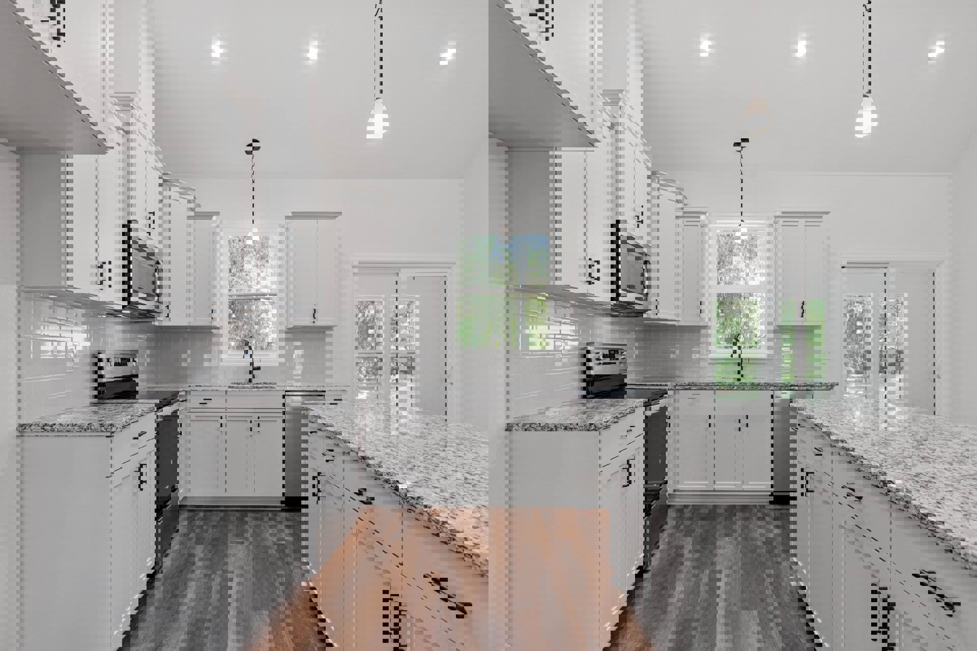 White kitchen cabinets with black handles, granite countertops, stainless steel microwave with open door, ceiling light fixture, and sink.