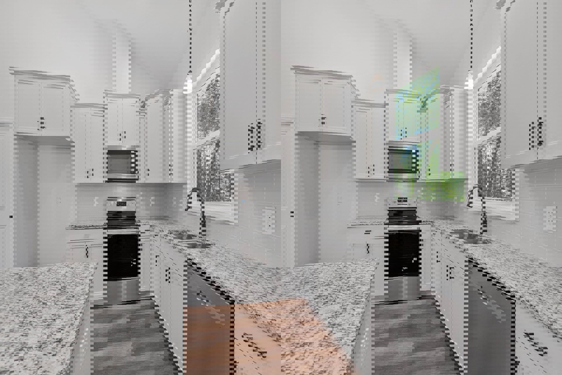 Granite countertops and white cabinets in a modern kitchen, stainless steel oven and microwave, marble-topped dishwasher, window overlooking trees