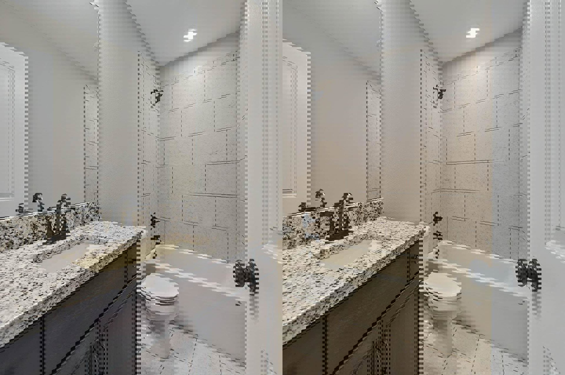 Marble countertop with undermount sink and chrome faucet, white toilet beside built-in bathtub, tile flooring, white paneled door with brushed metal doorknob