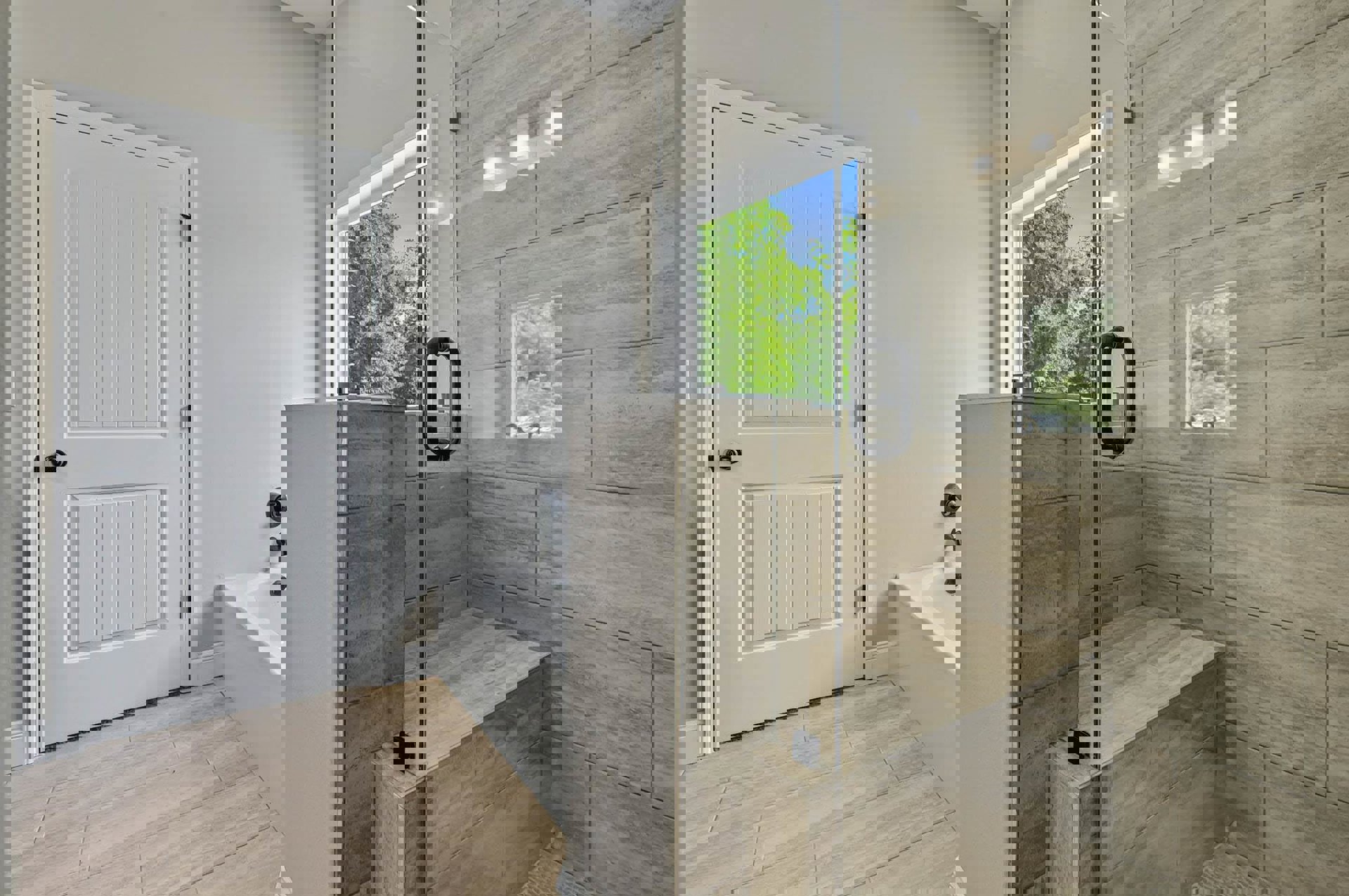 Bathroom with glass shower enclosure and freestanding tub, white tile floor, white door with black knob, large windows showing trees outside