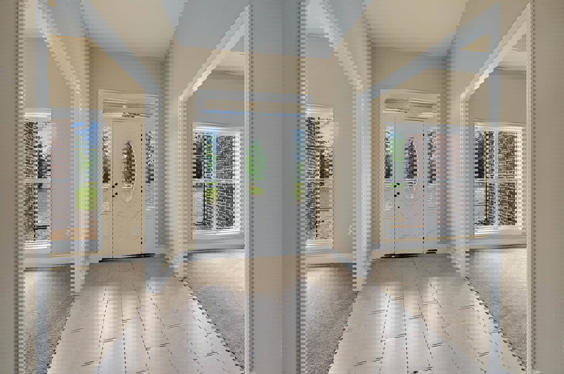 Hallway with tile flooring, white door featuring an oval window, side windows, and brick accent wall