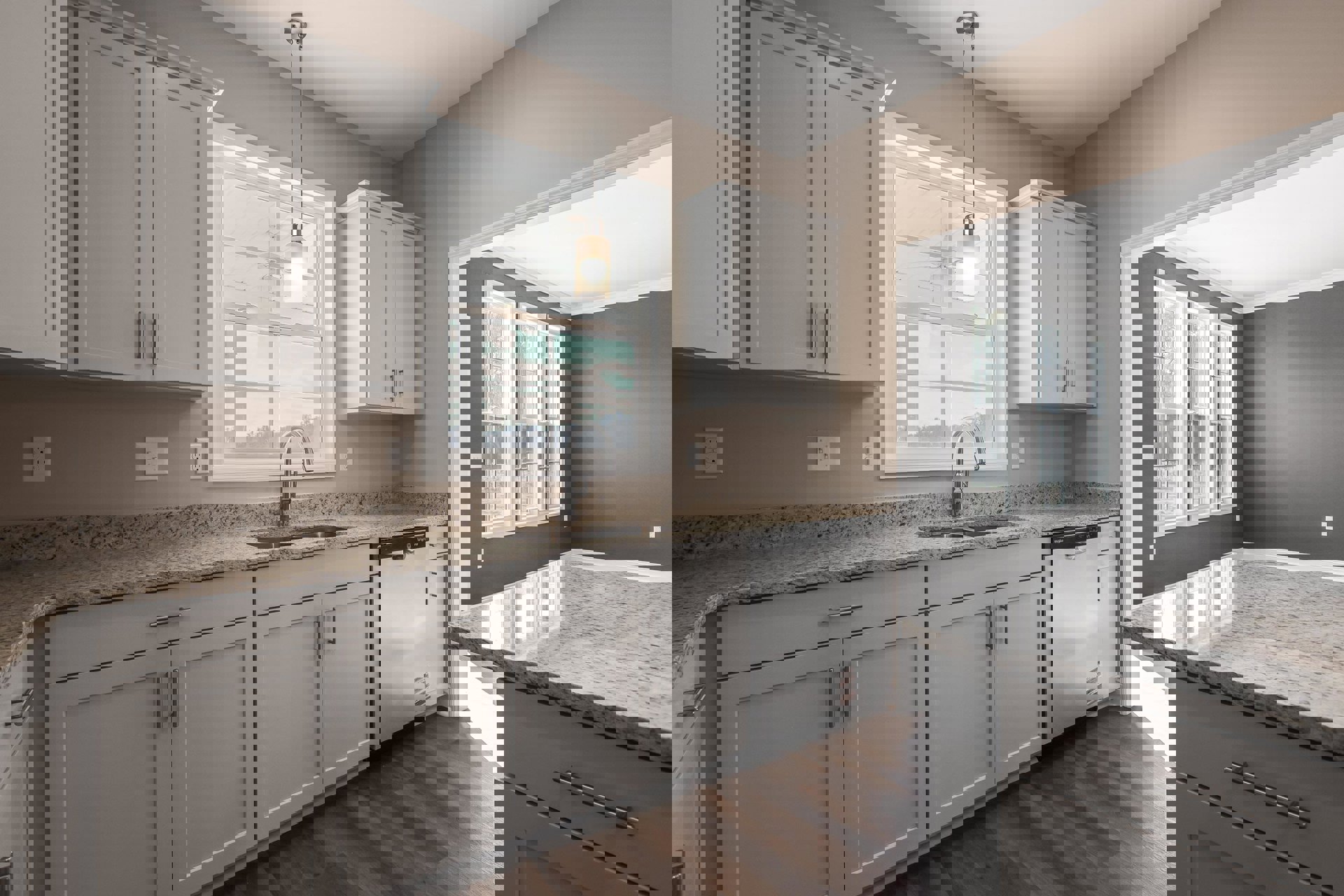 White kitchen cabinets with silver handles, granite countertops, stainless steel sink, built-in appliances, ceiling light fixture, wall outlet, and light switch.