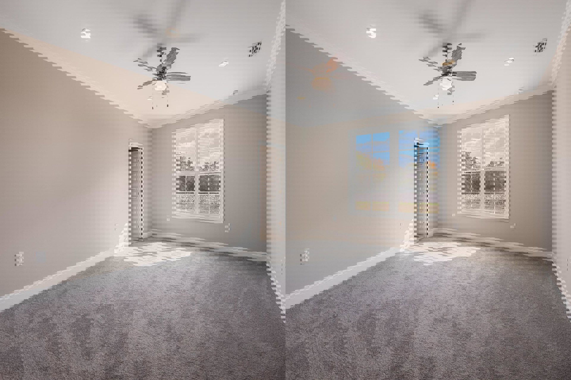 Bedroom with ceiling fan and light, large window overlooking grassy field, white paneled door open to hallway, wall vent, neutral walls, and wood flooring