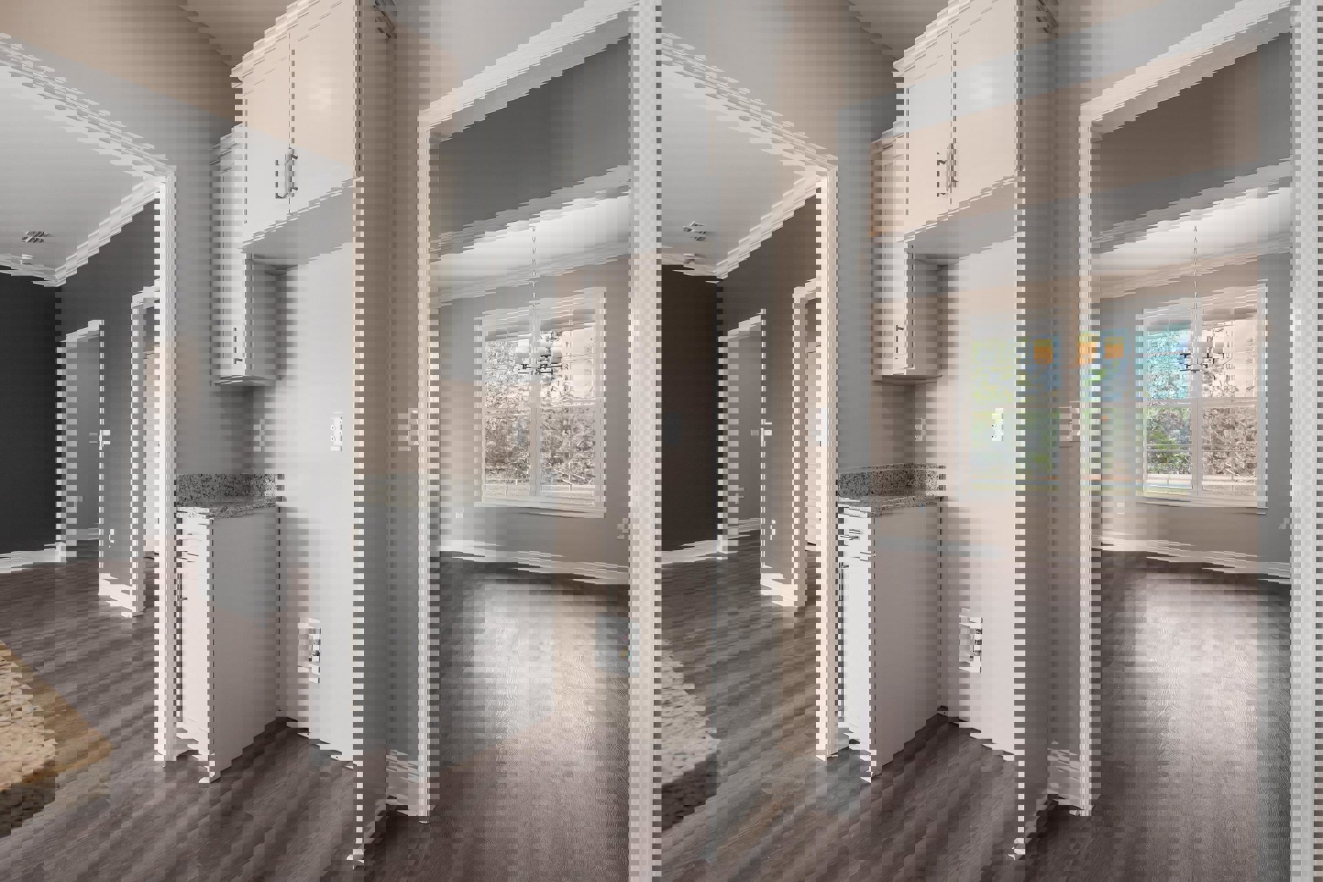 White cabinetry with shaker-style doors, wood plank flooring, large windows, and a modern pendant light fixture.