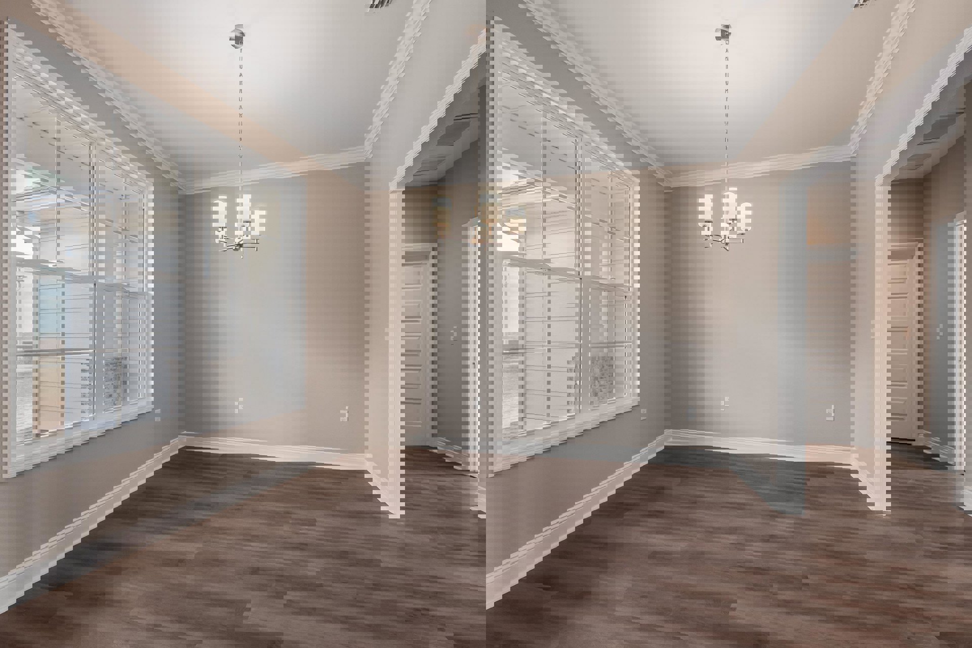 Chandelier hanging from white ceiling above hardwood floor, white baseboards, glass-paned window, and white door with silver chain visible.