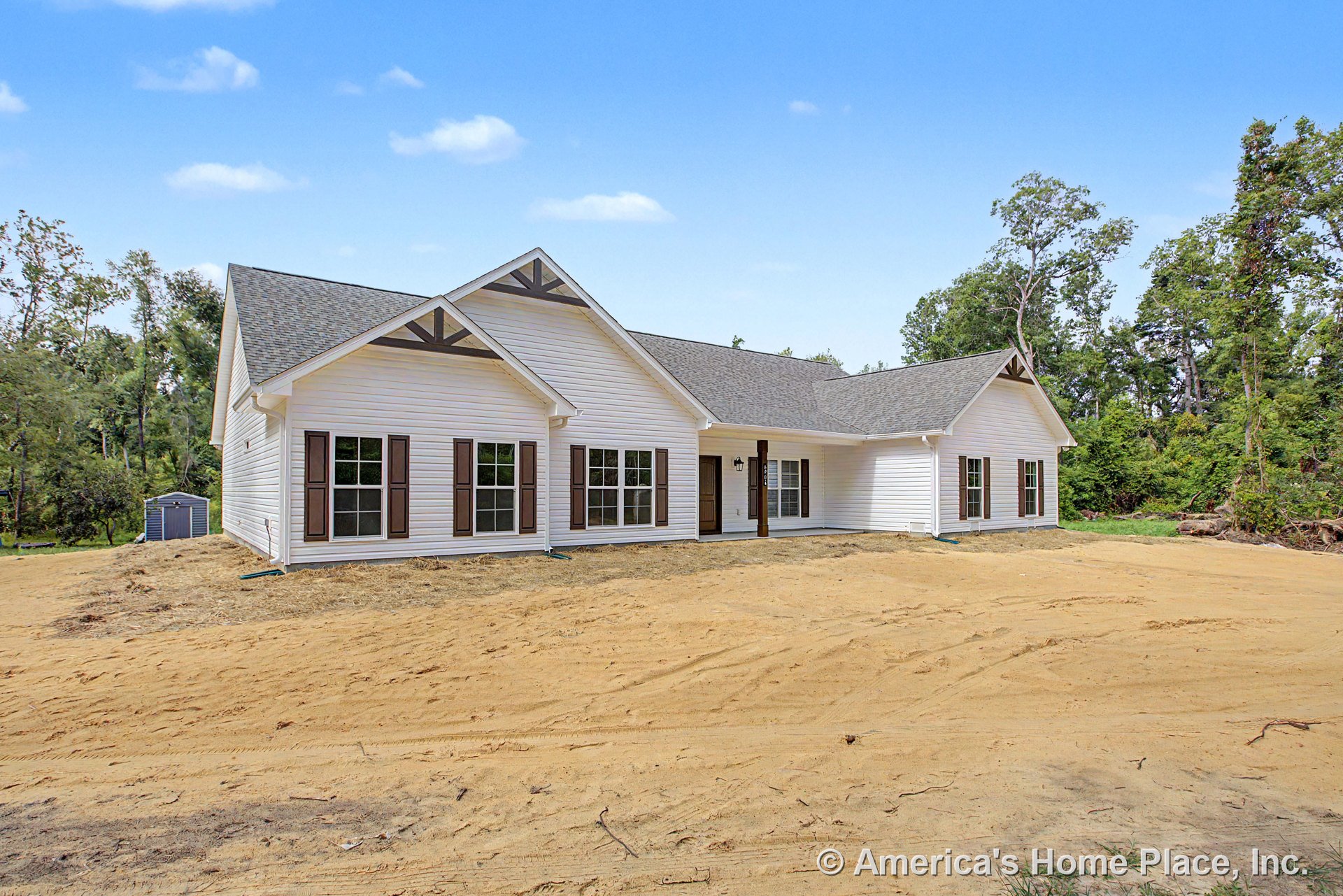 White vinyl siding exterior with prominent gable rooflines, covered front porch, multiple large windows framed by brown shutters, decorative trim accents in gables, entry door