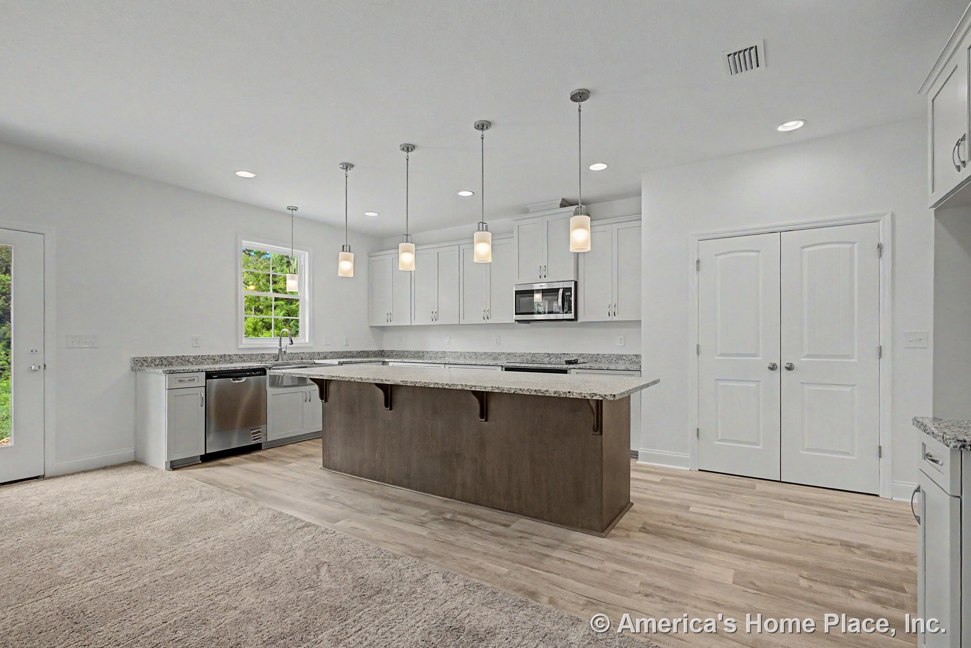 Spacious kitchen with granite island, white shaker cabinets, stainless steel appliances, farmhouse sink, pendant and recessed lighting, double pantry doors, wood-look flooring, and