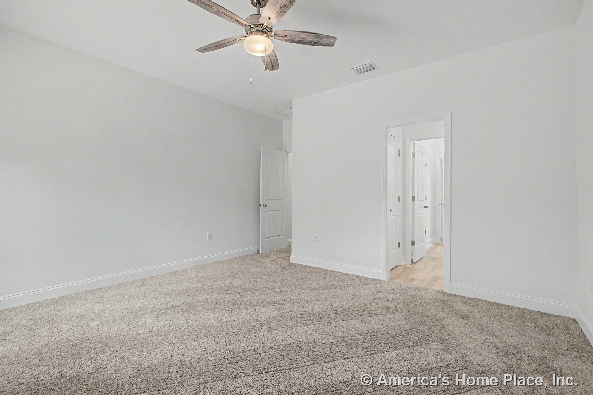 Bedroom with light carpet flooring, white walls, white baseboards, ceiling fan with integrated light, smooth white ceiling, white paneled doors, and hallway transition to wood