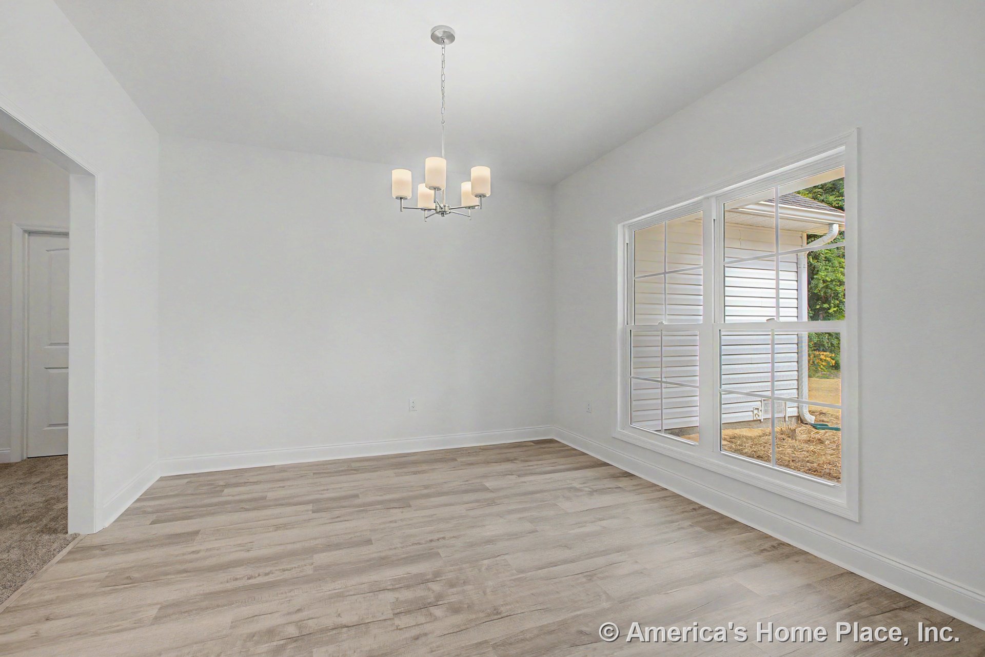Dining area with large double windows, light wood-look flooring, modern chandelier, white trim, open doorway, and smooth white ceiling.