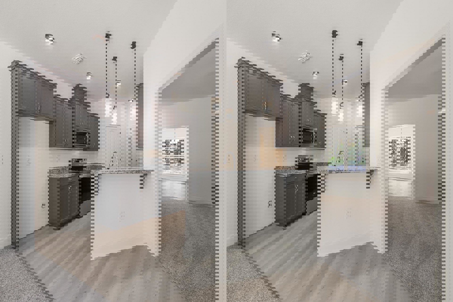 Open-concept kitchen and living room featuring white walls, gray cabinets, granite countertop, stainless steel microwave, window with pendant light, and black support pole