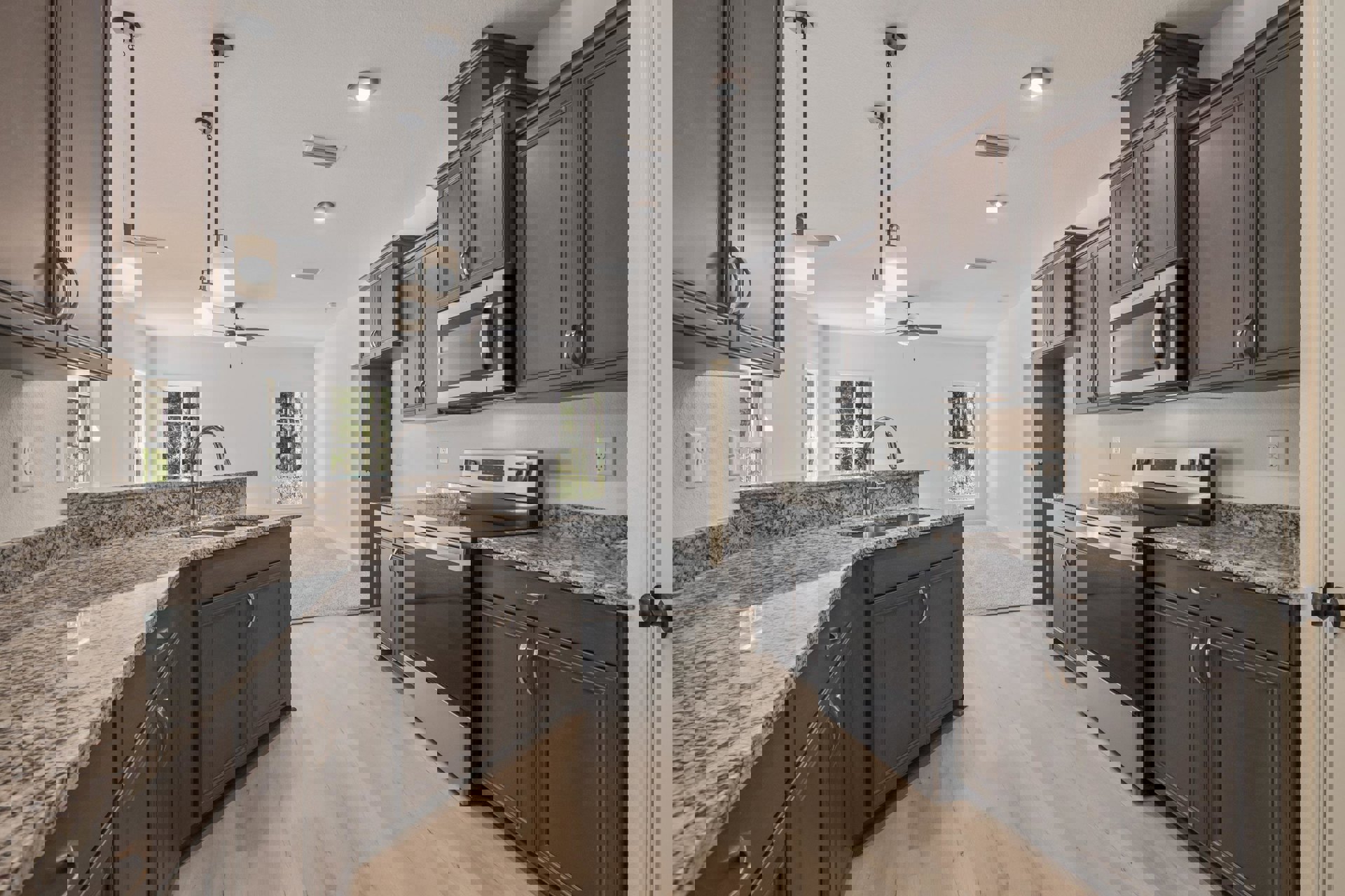 Granite countertops with undermount sink, stainless steel microwave, dishwasher, black refrigerator, white cabinetry, wall-mounted light fixture