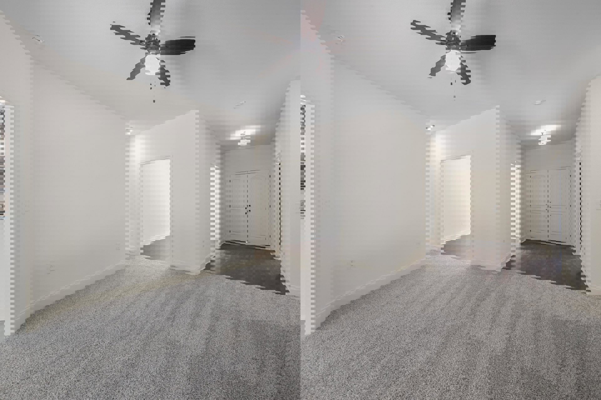 Carpeted room with white walls, ceiling fan with light, double white doors featuring black knobs, and open door leading to adjacent space