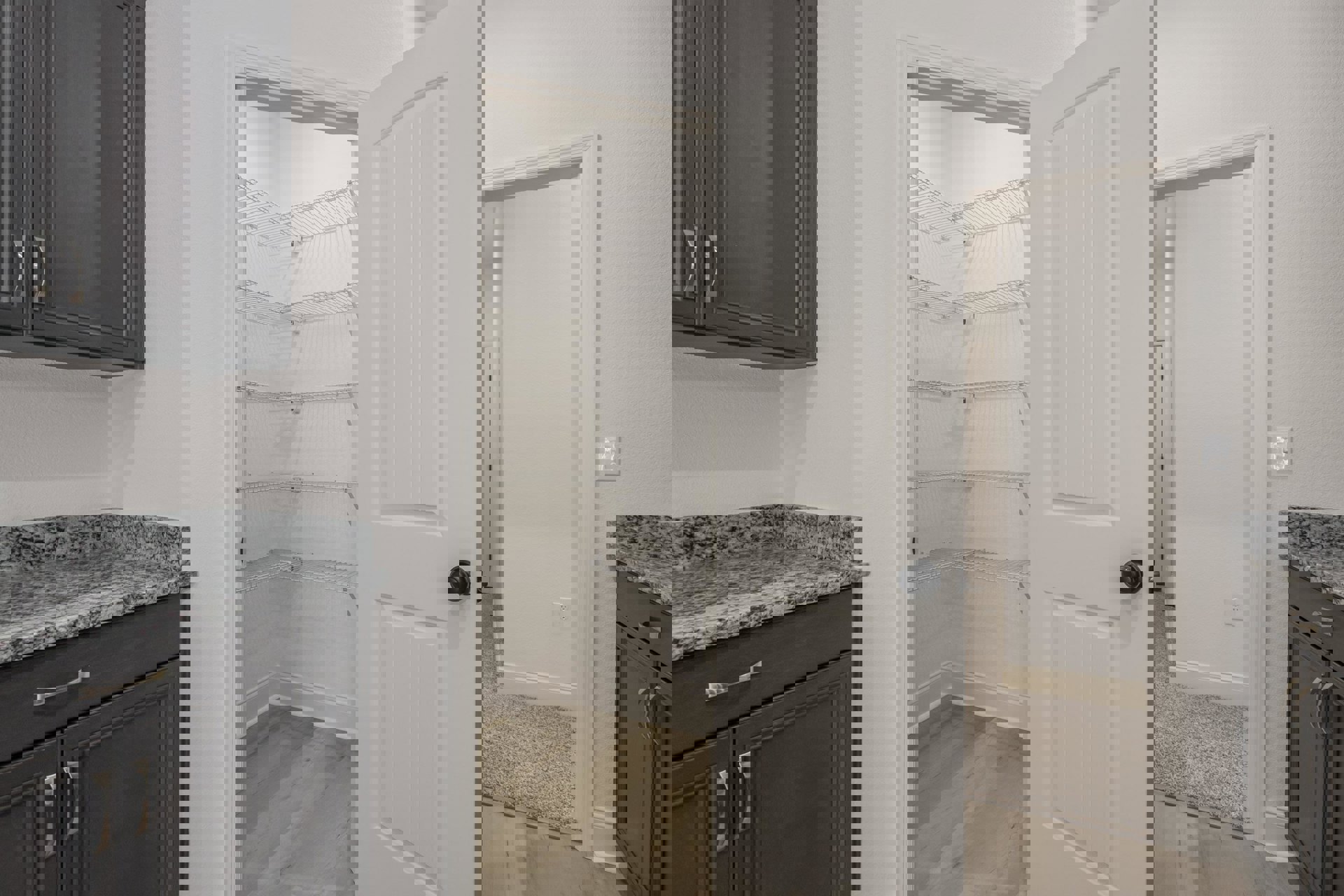 Walk-in closet with white shelving, wood flooring, white trim, and a white door featuring a black knob