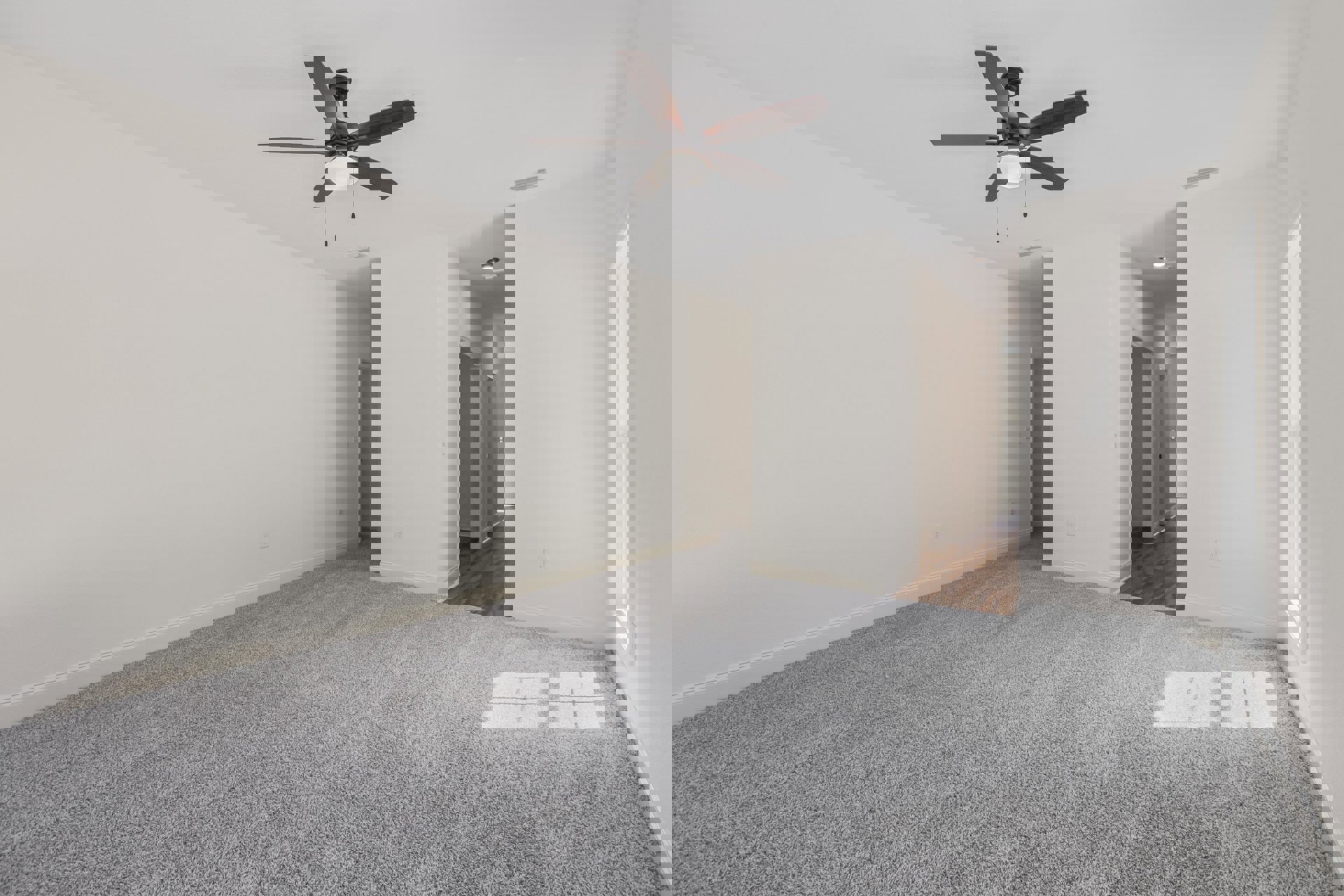 Carpeted room with white walls, ceiling fan with light fixture, simple interior design