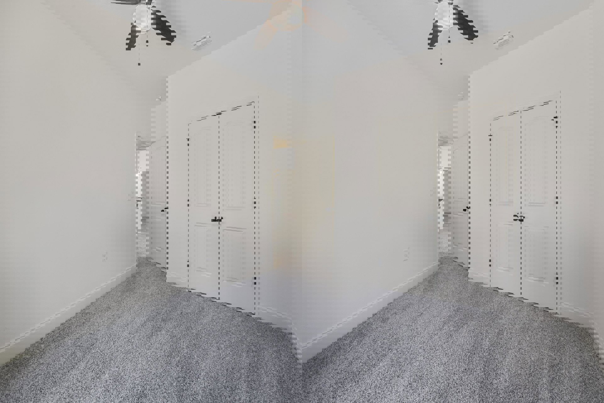 Carpeted room with white double doors featuring black knobs, ceiling fan with light fixture, neutral walls and trim
