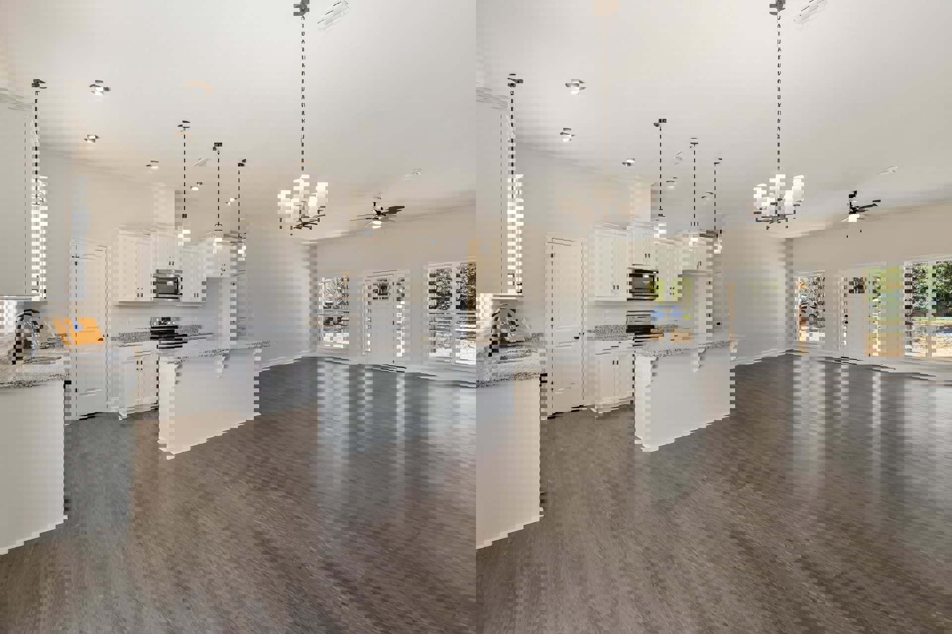 Spacious open-concept kitchen with hardwood flooring, central white island, marble countertops, built-in microwave, white cabinetry, black hardware, and modern light fixture on