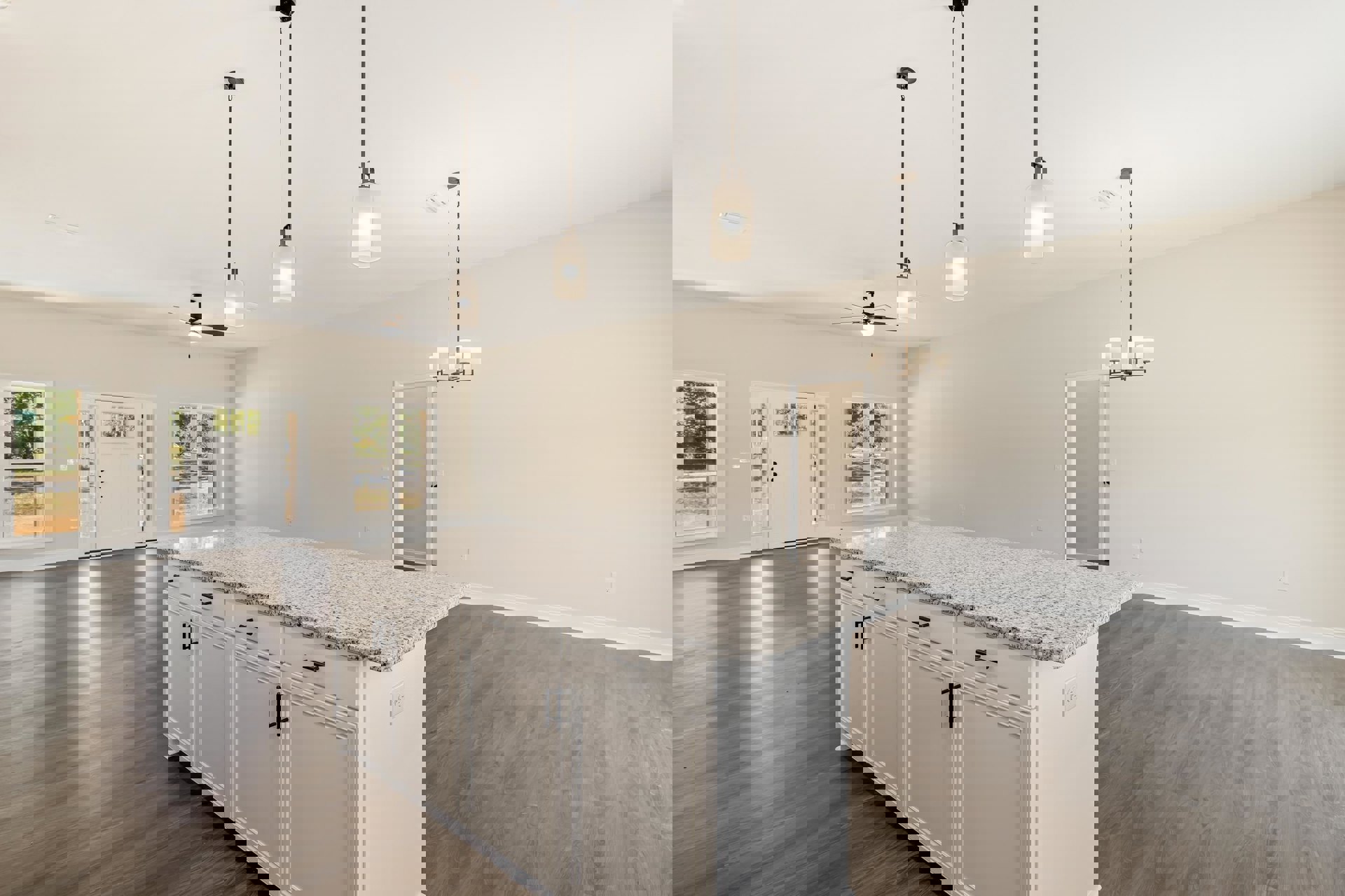 White kitchen island with black handles and marble countertop, window overlooking trees, wall-mounted light fixture, white door with glass panels, tile flooring, cabinetry